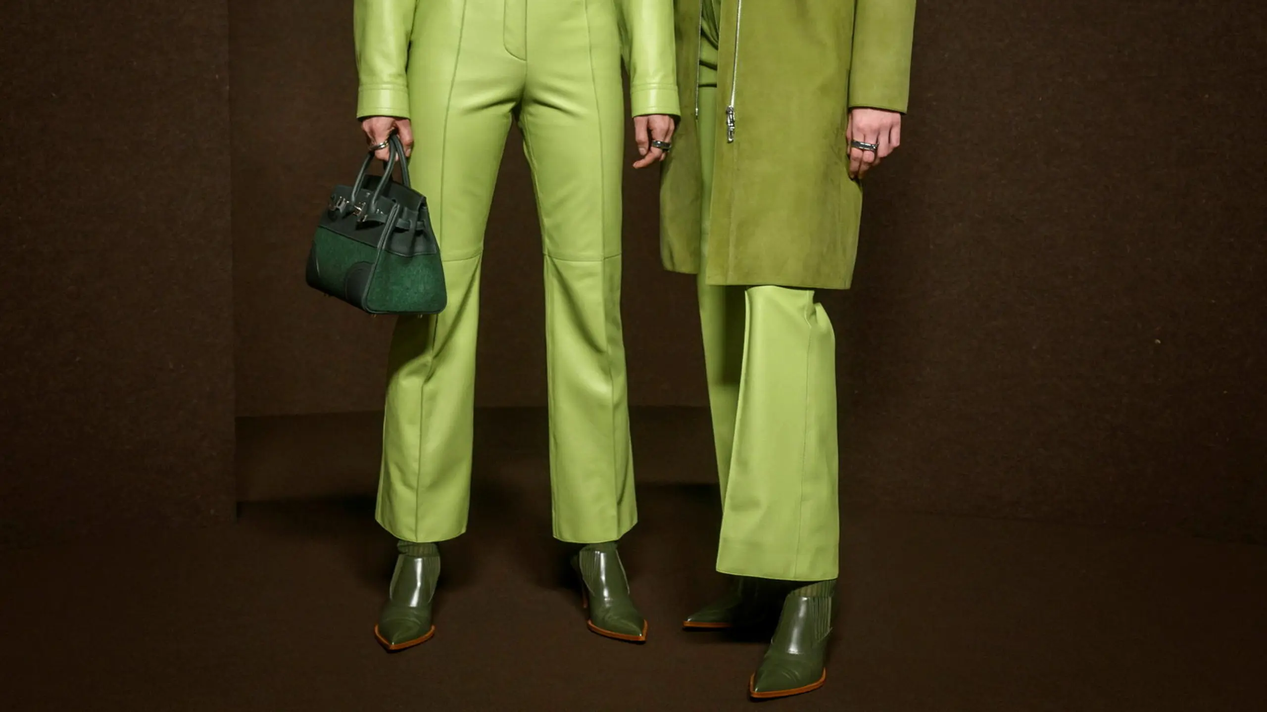 Zwei Models sichtbar bis zur Taille mit komplett grünen Outfits und grünen Schuhen