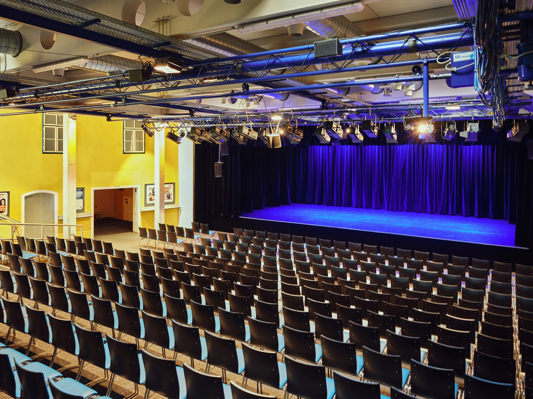 Theatersaal mit Bühne, Vorhang und Sitzplätzen