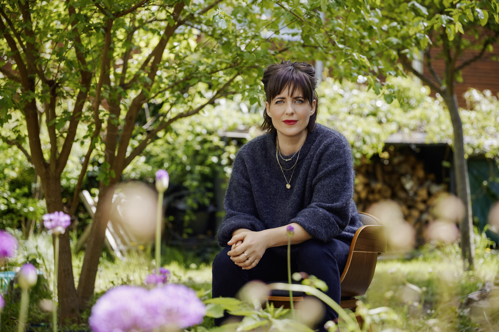 Sarah Kuttner sitzt in einem Garten