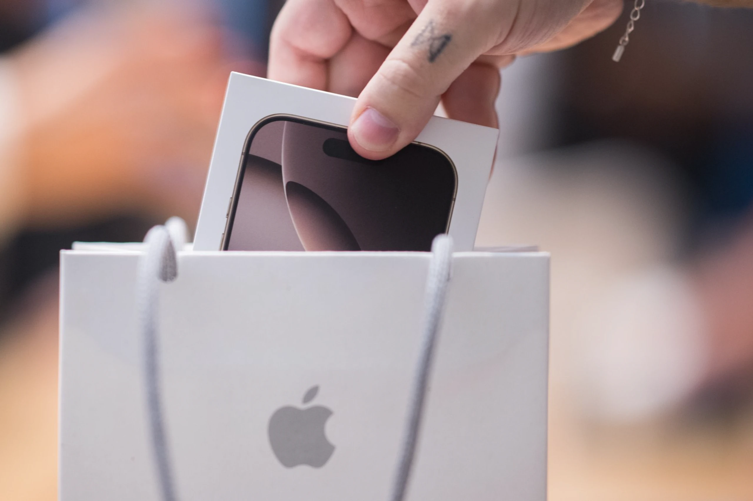 Iphone-Verpackung wird in Tüte von Iphone gesteckt; Logo von Apple sichtbar