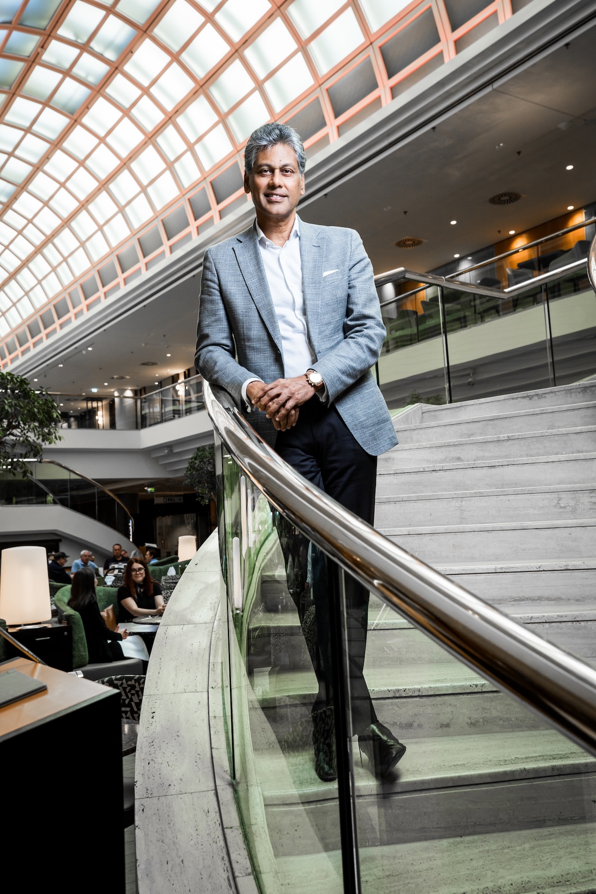 Satya Anand steht in einem grauen Anzug in einem seiner Marriott-Hotels und lächelt in die Kamera.