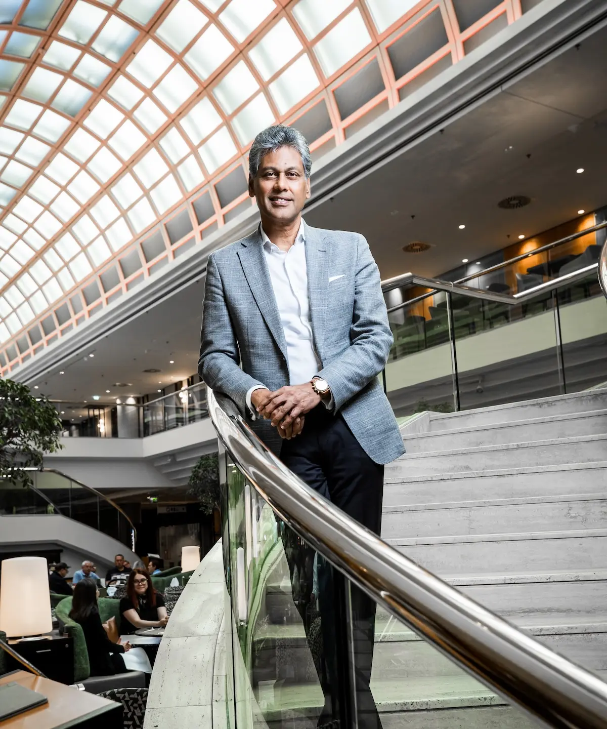© Lukas Ilgner Satya Anand steht in einem grauen Anzug in einem seiner Marriott-Hotels und lächelt in die Kamera.
