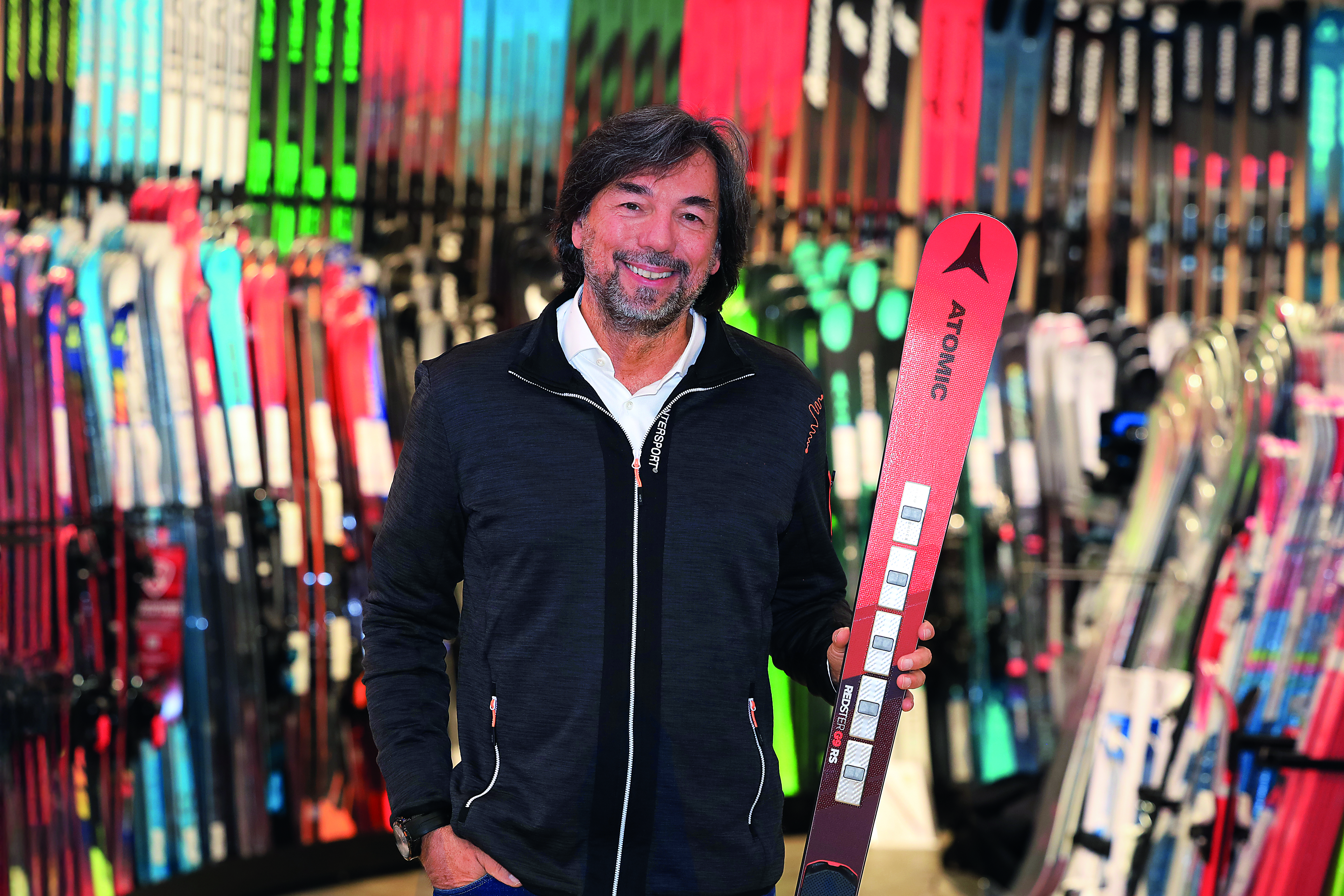 Intersport-CEO Franz Koll in einer Intersport-Filiale mit einem Ski in der Hand.