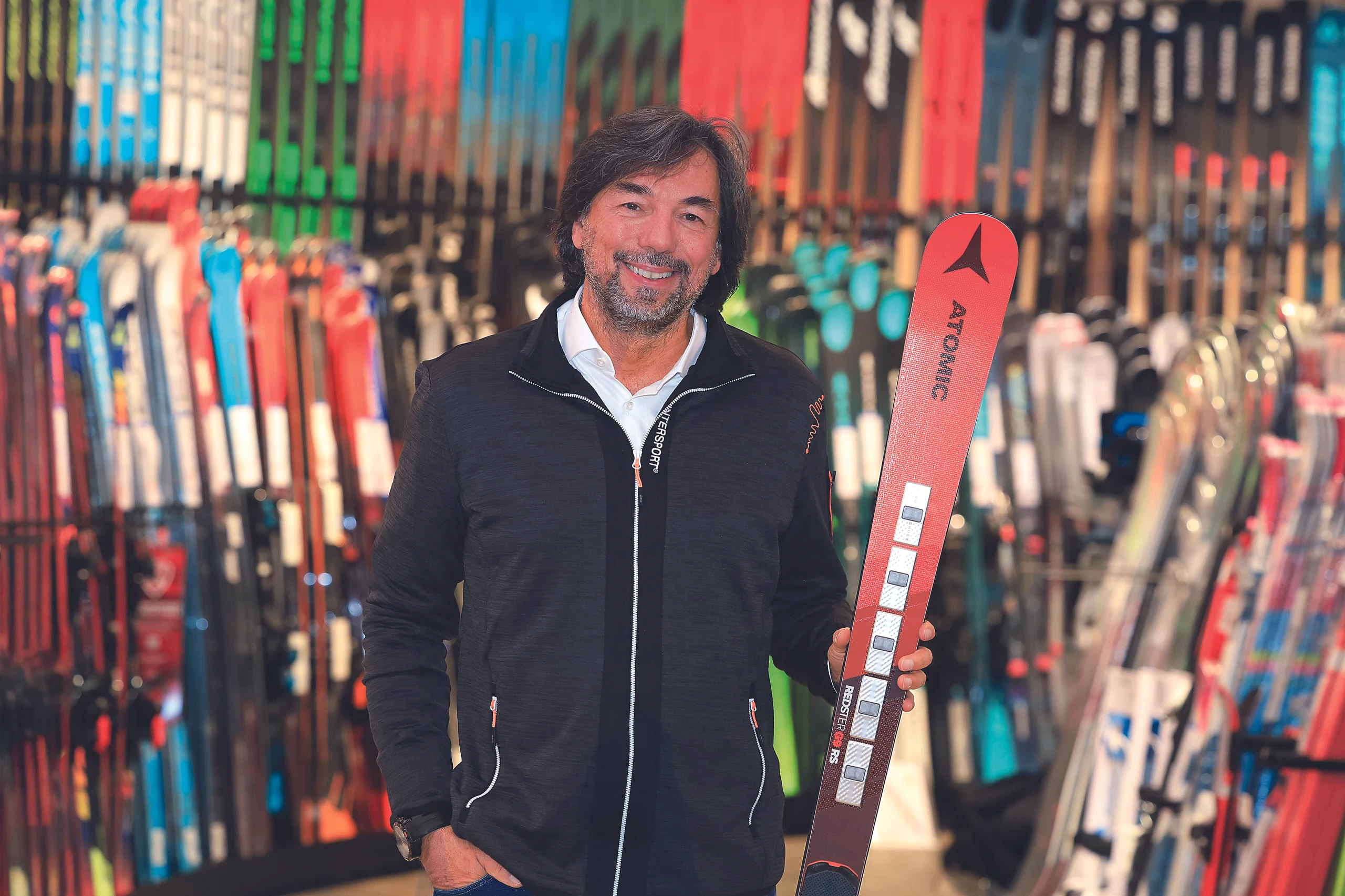 Intersport-CEO Franz Koll in einer Intersport-Filiale mit einem Ski in der Hand.