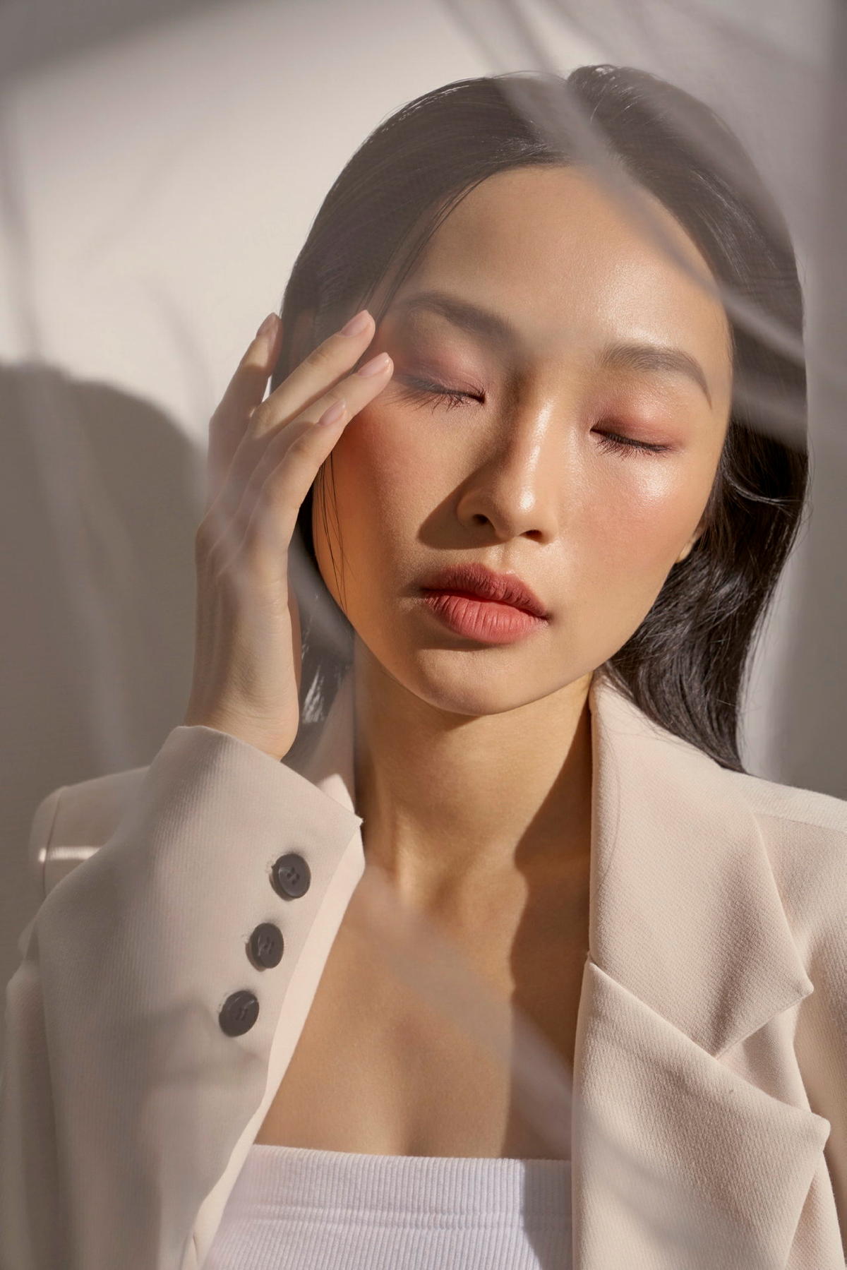 Frau mit geschlossenen Augen greift sich an die Schläfe