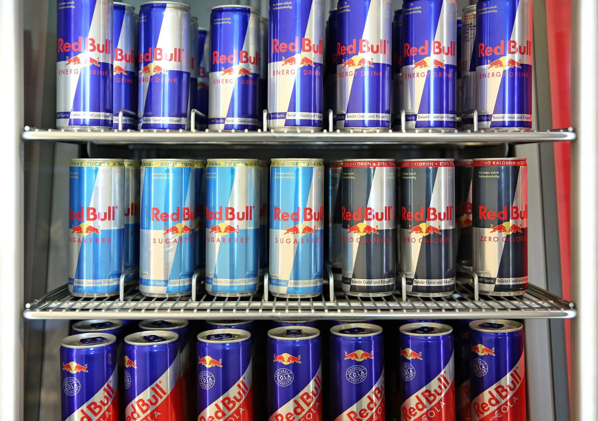 Getränkedosen der Firma Red Bull in einem Regal