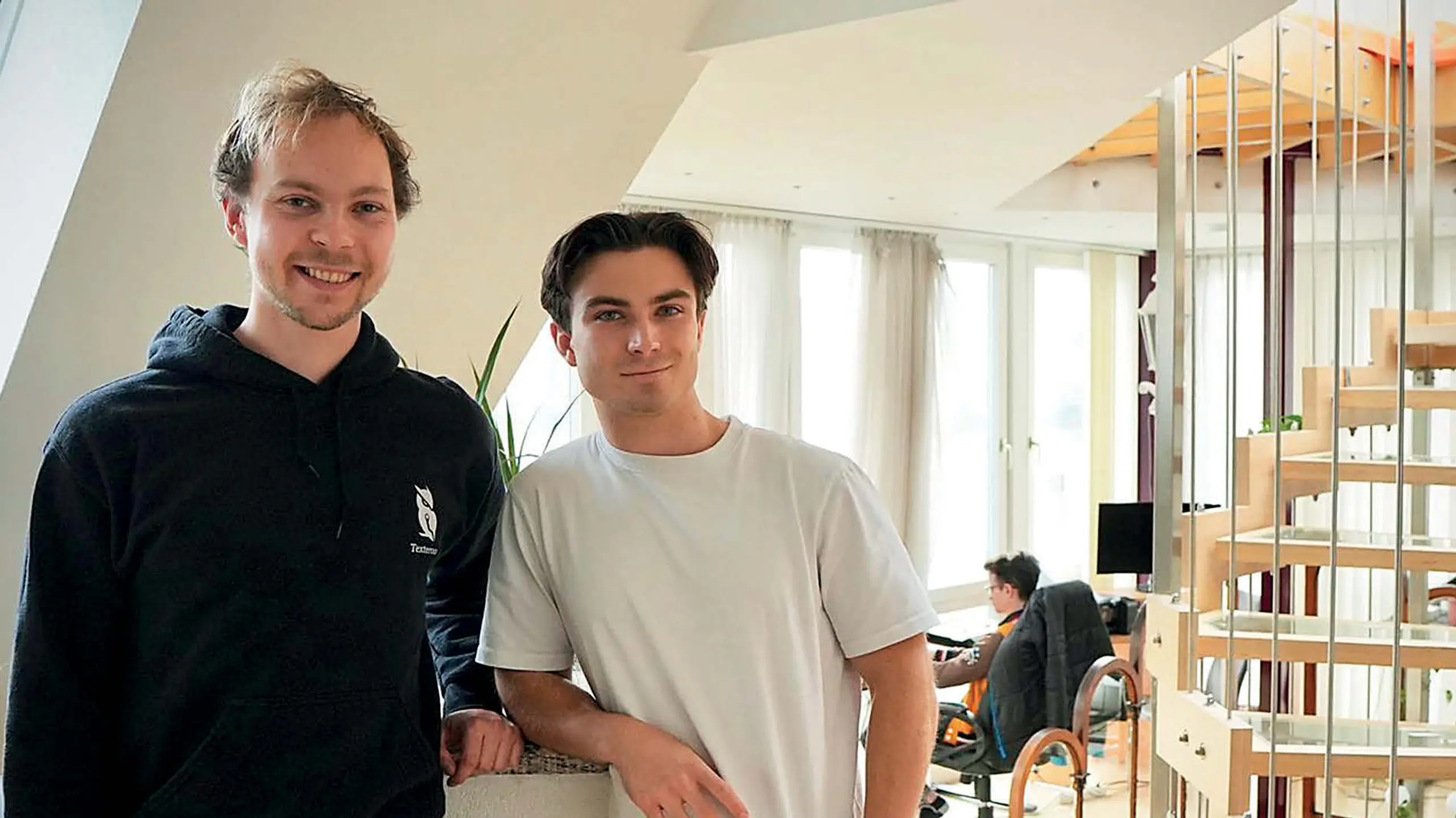 © trend/Clemens Schreiber Zwei Männer in einem Wohnzimmer, Wendeltreppe rechts im Bild