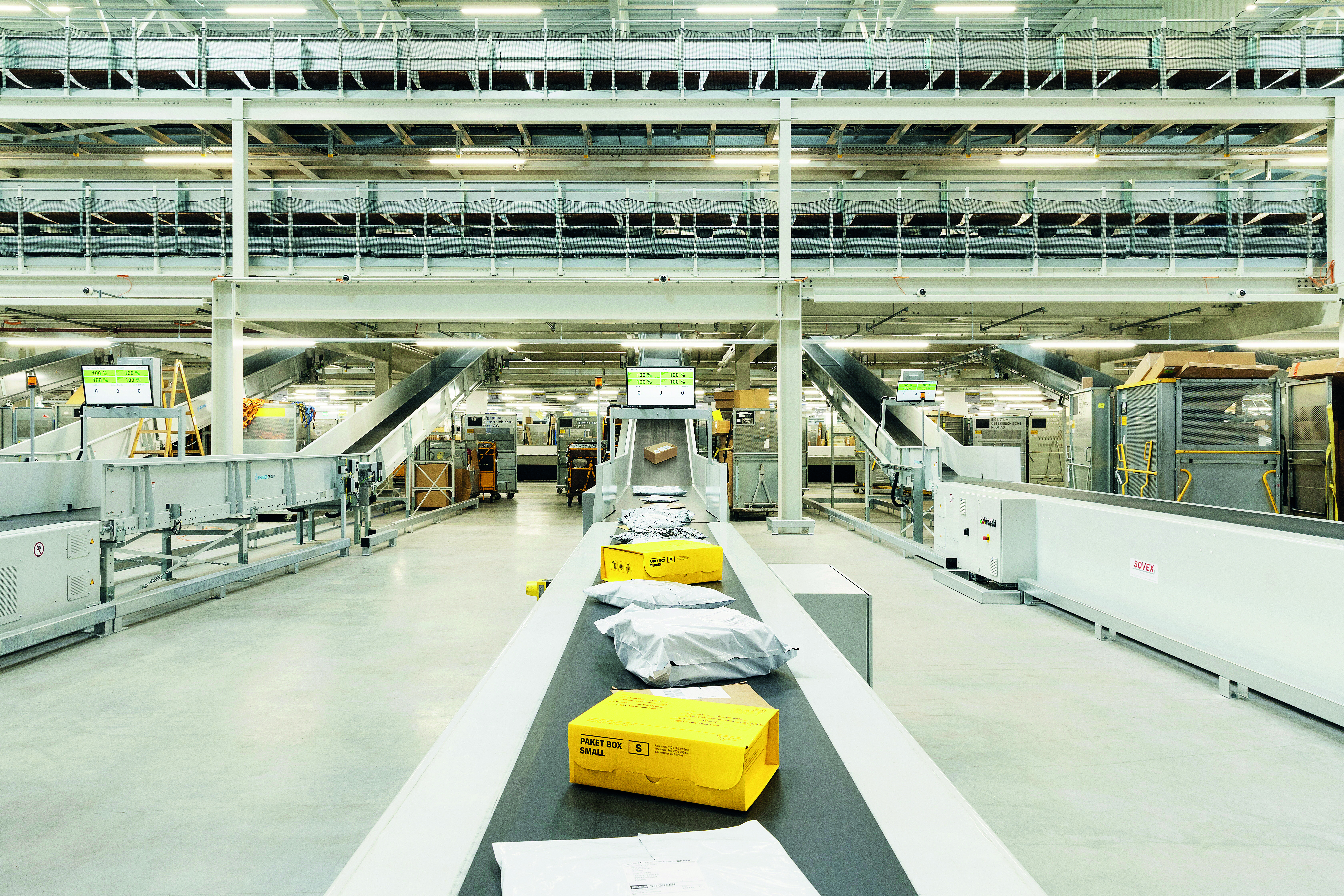 Lagerhalle, in der ein Fließband mit Paketen zu sehen ist