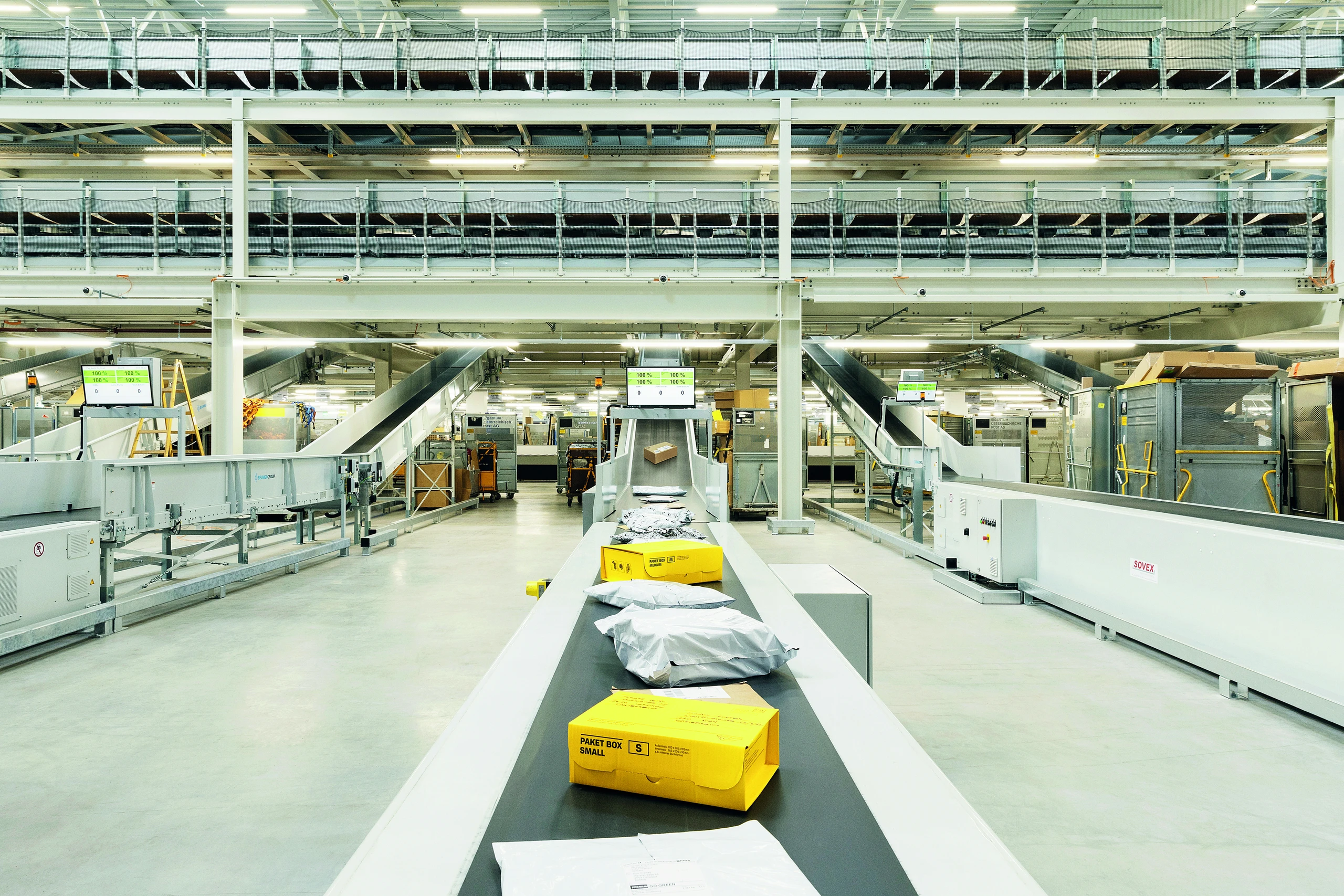 Lagerhalle, in der ein Fließband mit Paketen zu sehen ist
