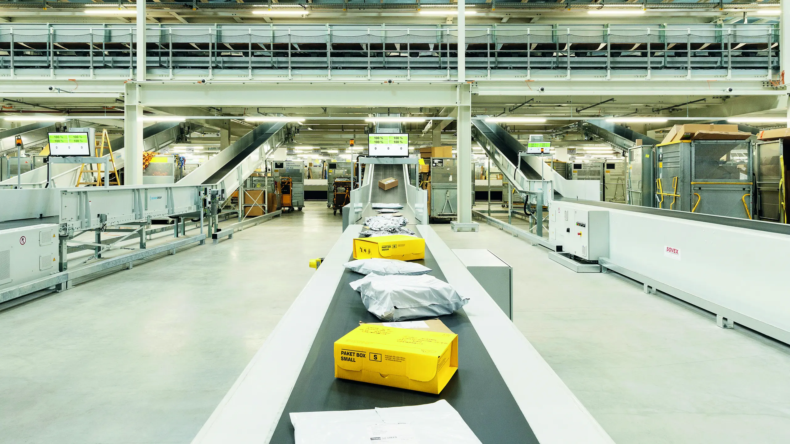 © Post AG/Christian Stemper Lagerhalle, in der ein Fließband mit Paketen zu sehen ist