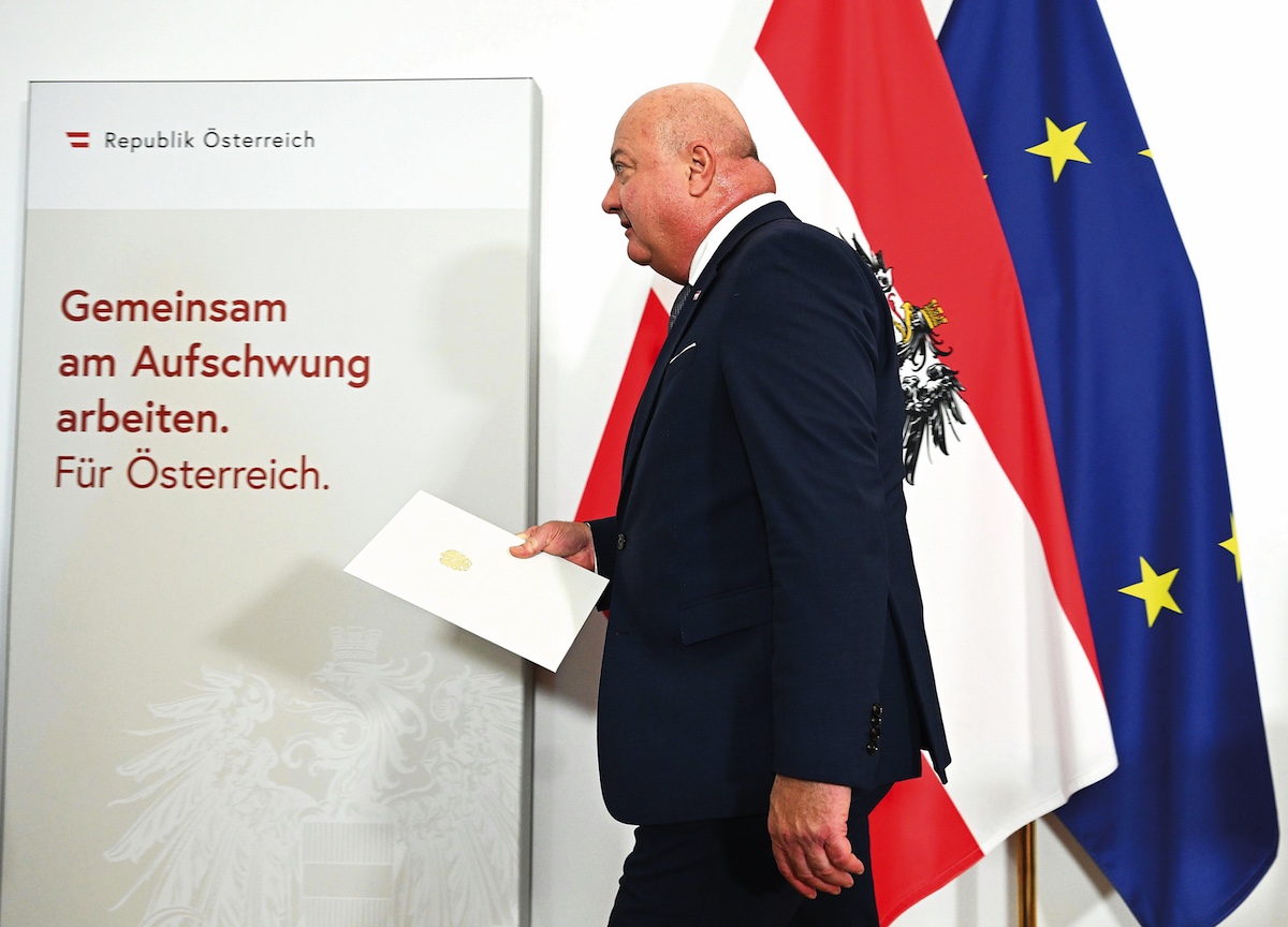 Bundeskanzler Christian Stocker vor österreichischen Flagge und EU-Flagge.