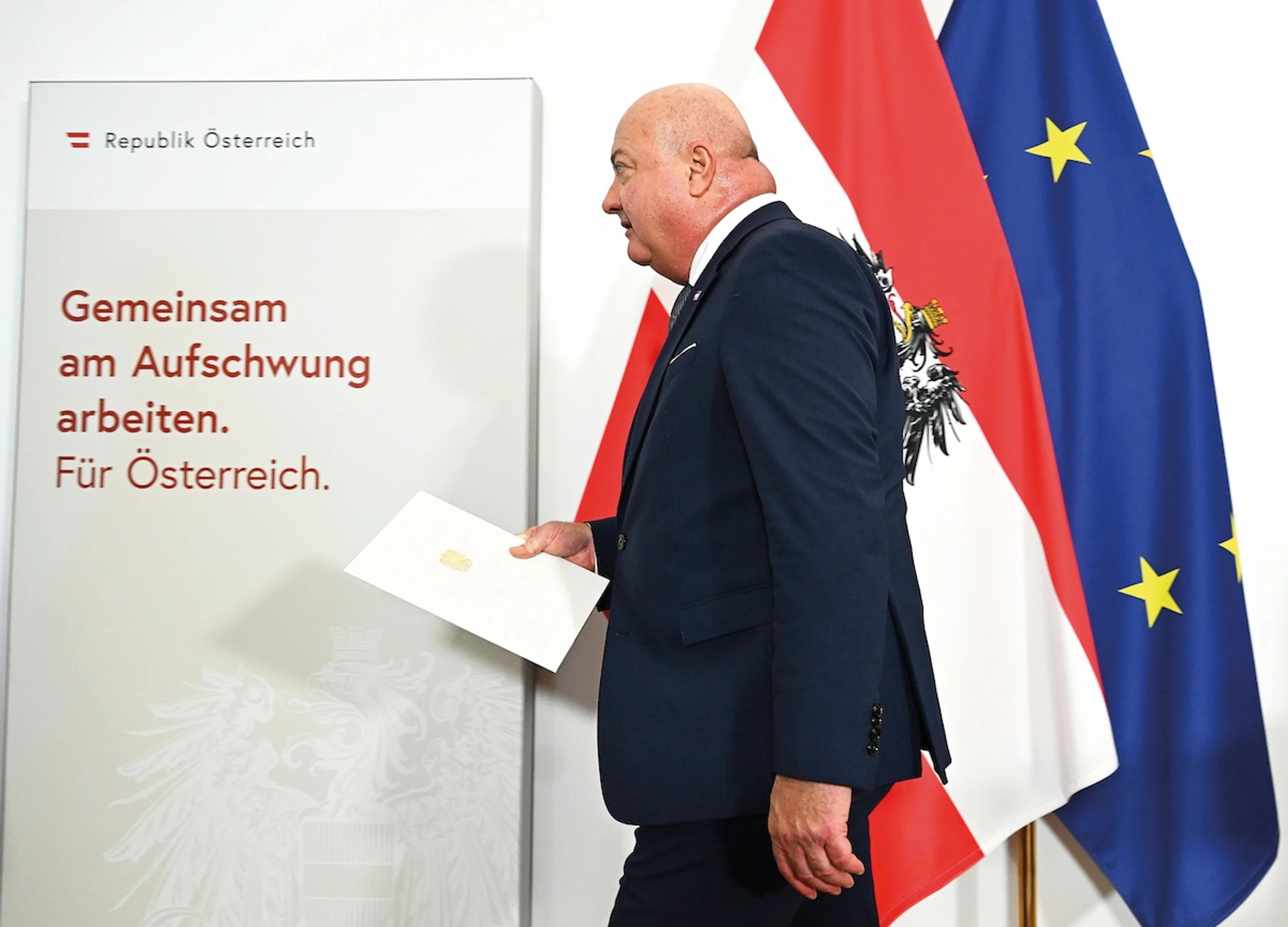 Bundeskanzler Christian Stocker vor österreichischen Flagge und EU-Flagge.