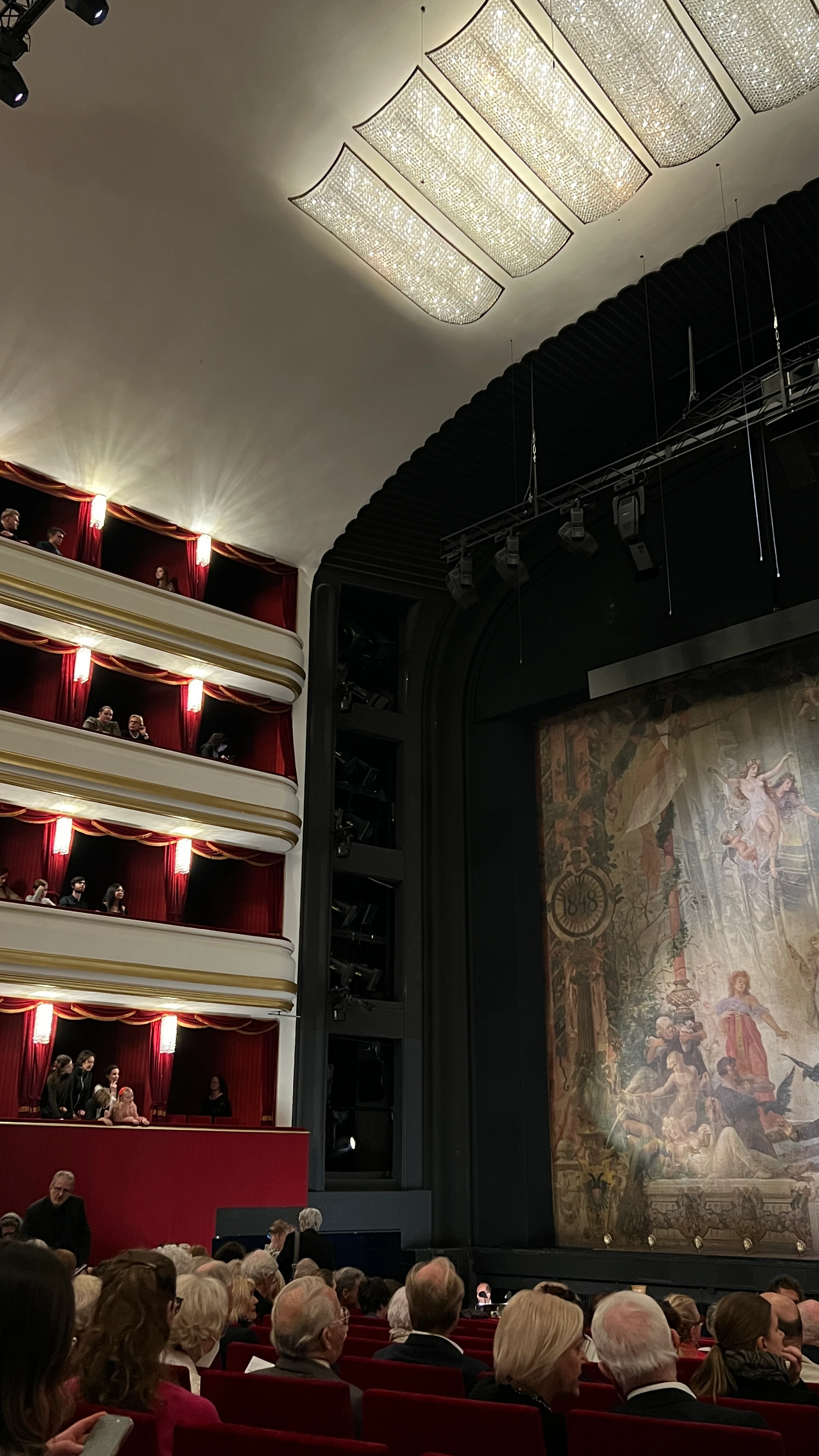 Innenaufnahme eines Theaters mit Publikum, Bühne und Logen