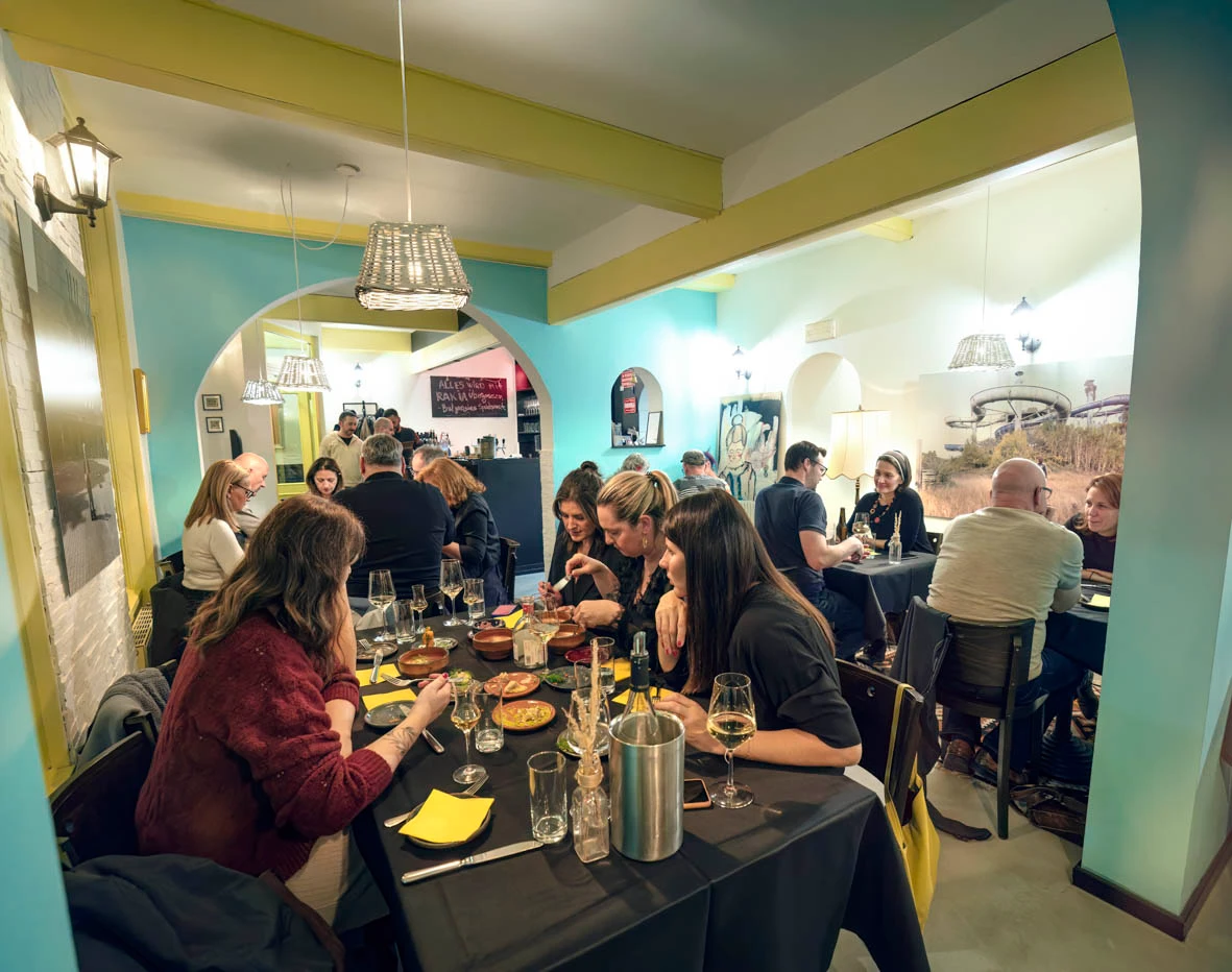 Gemütliches Restaurant mit Gästen beim Abendessen. Stimmungsvolle Beleuchtung und moderne Einrichtung laden zum Verweilen ein.