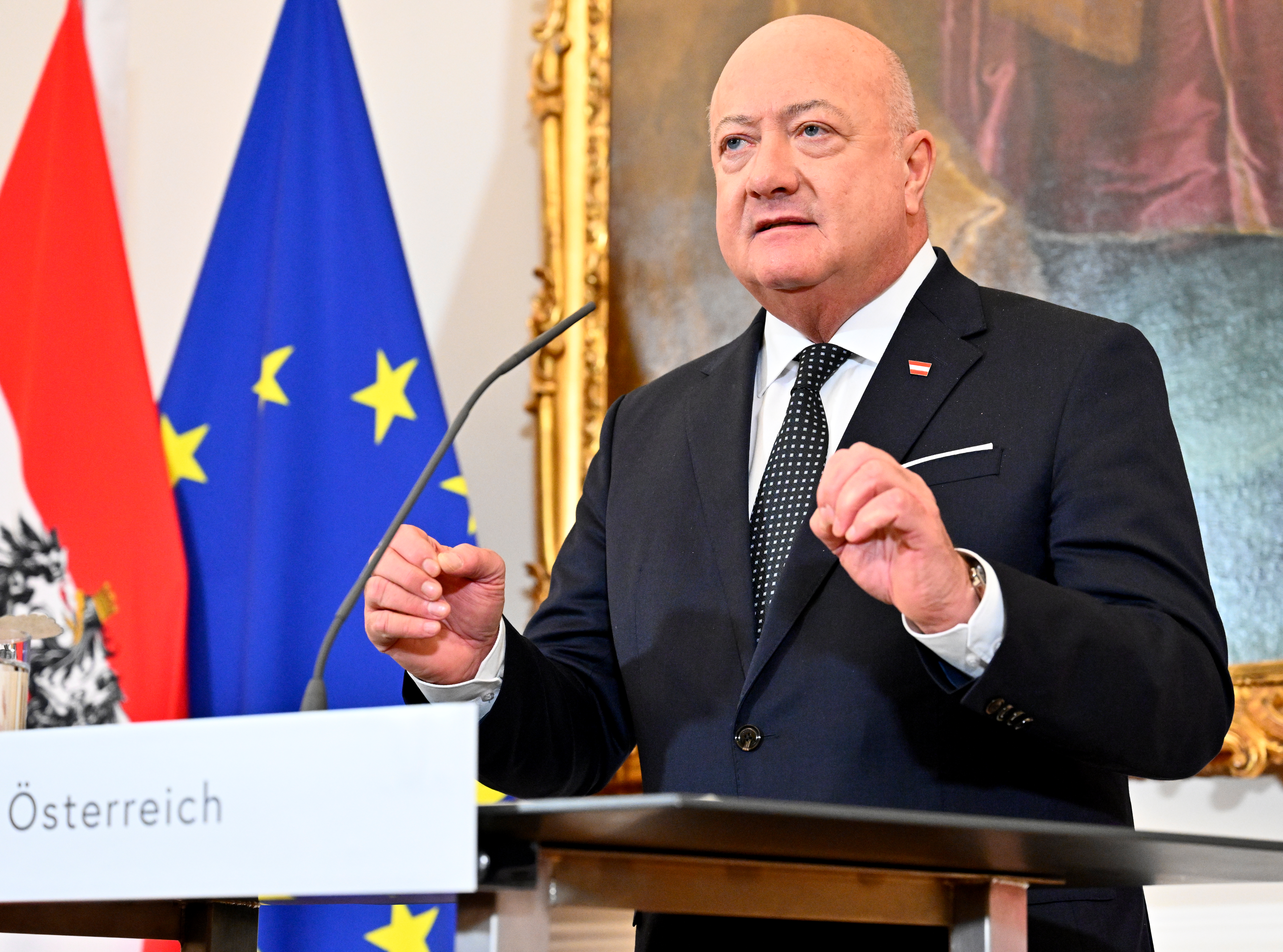 Christian Stocker am Redepult vor Österreich- und EU-Flagge