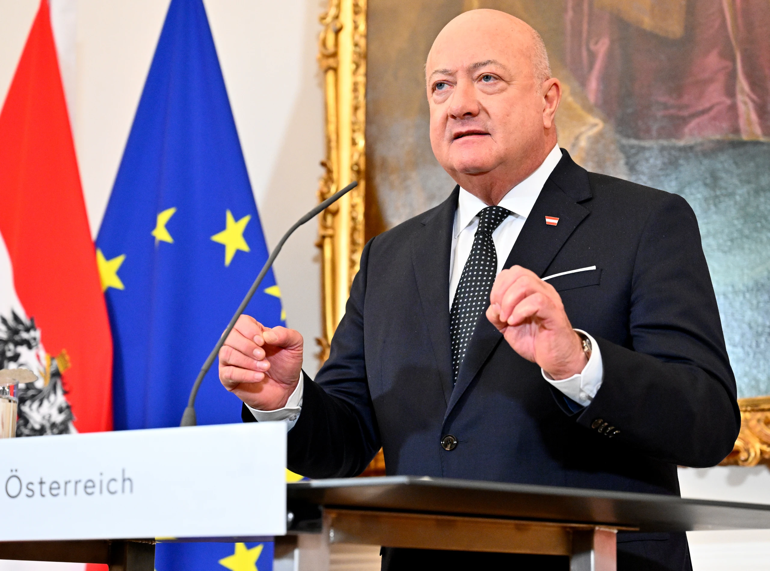 Christian Stocker am Redepult vor Österreich- und EU-Flagge