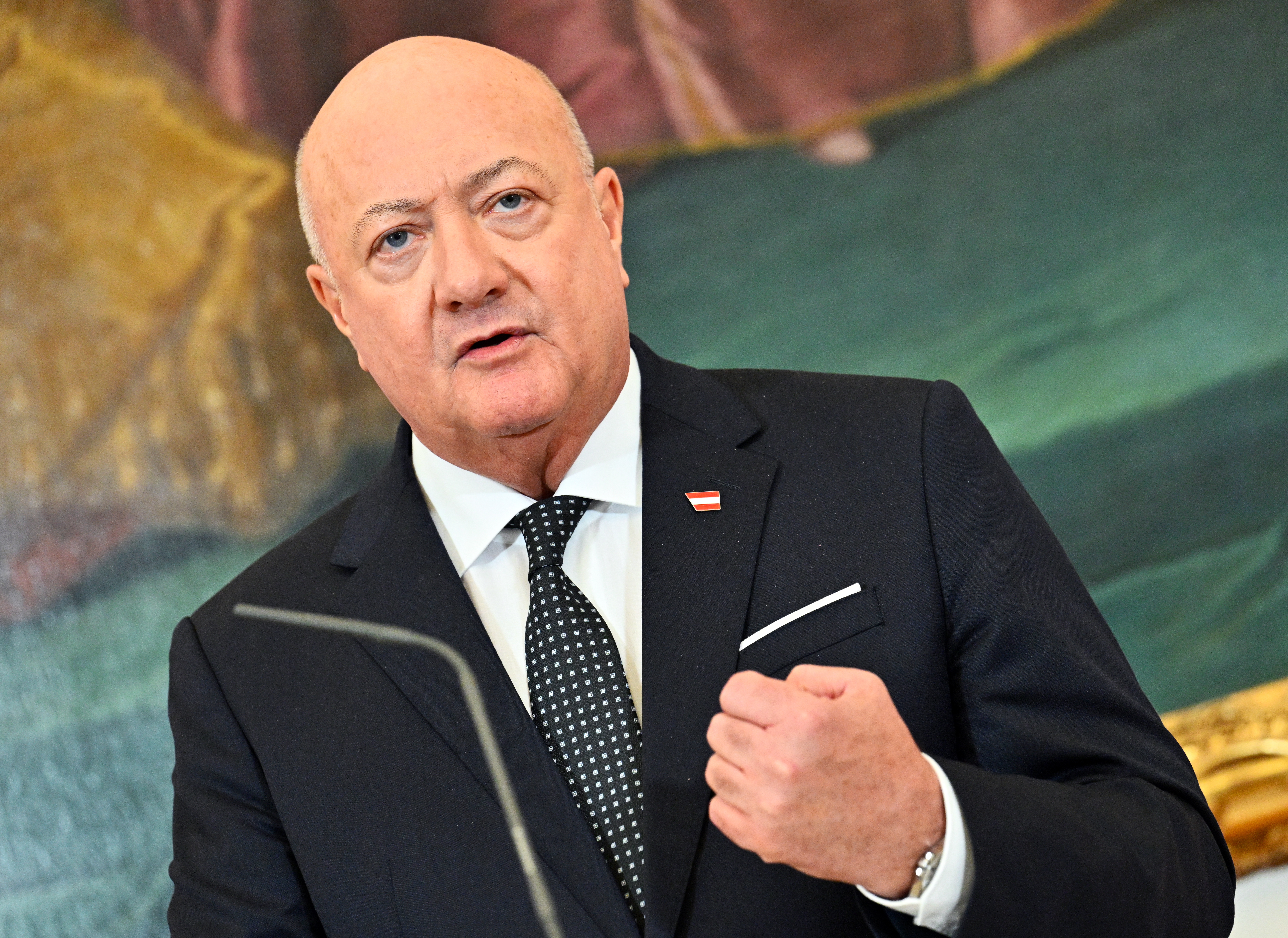 Christian Stocker hält eine Rede vor farbigem Hintergrund