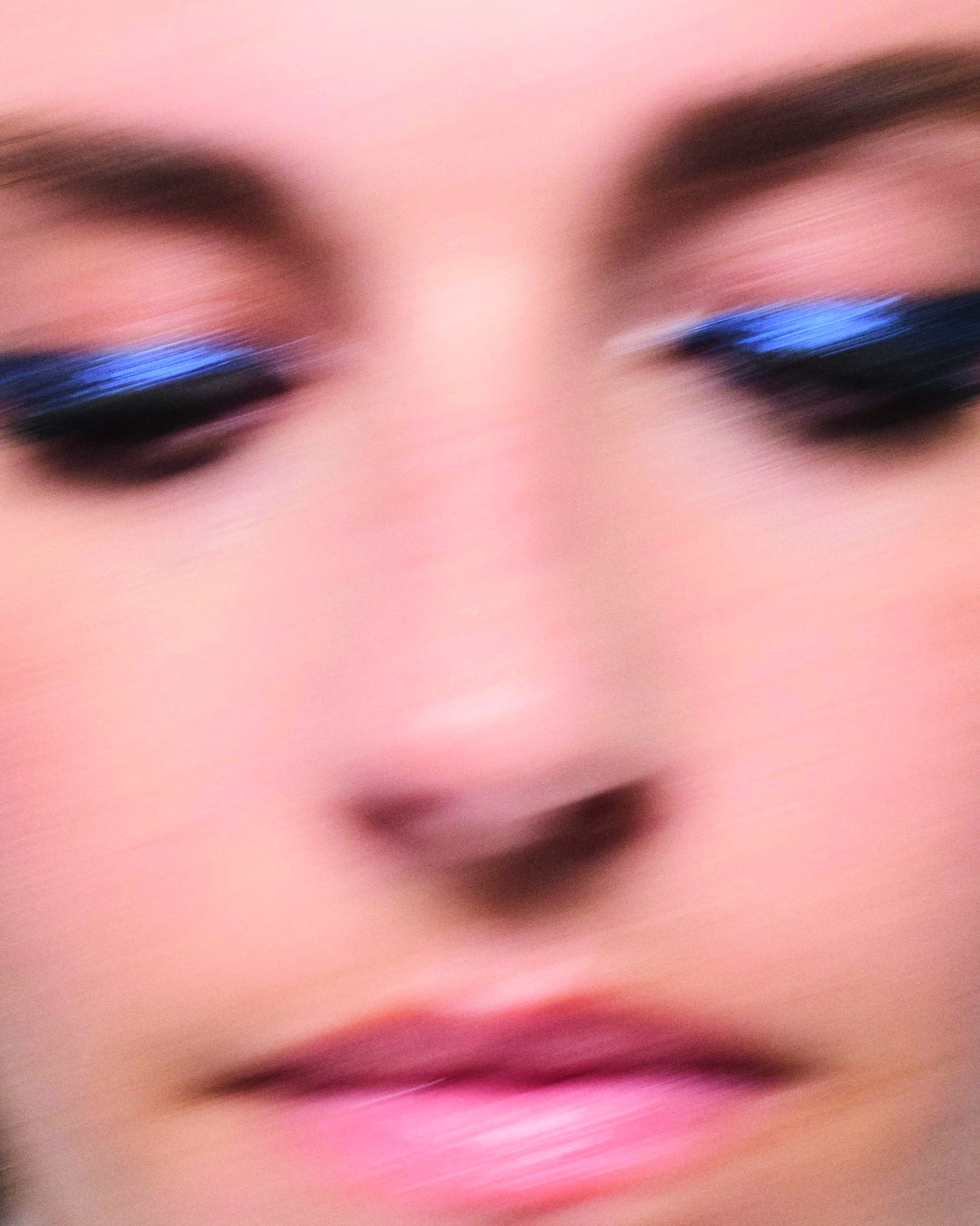 Close-up von verschwommenem Gesicht mit glitzerndem blauen Lidschatten