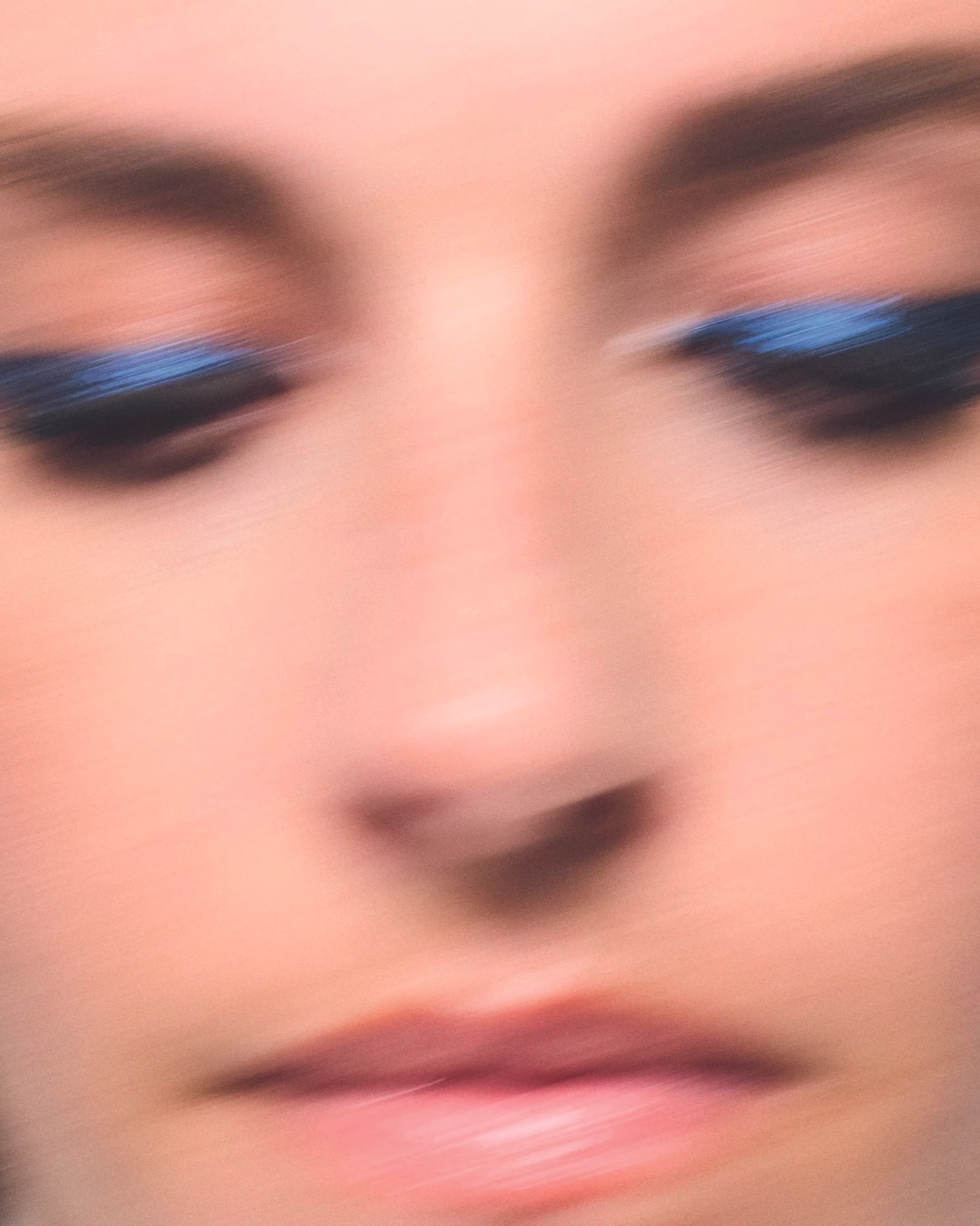 Close-up von verschwommenem Gesicht mit glitzerndem blauen Lidschatten