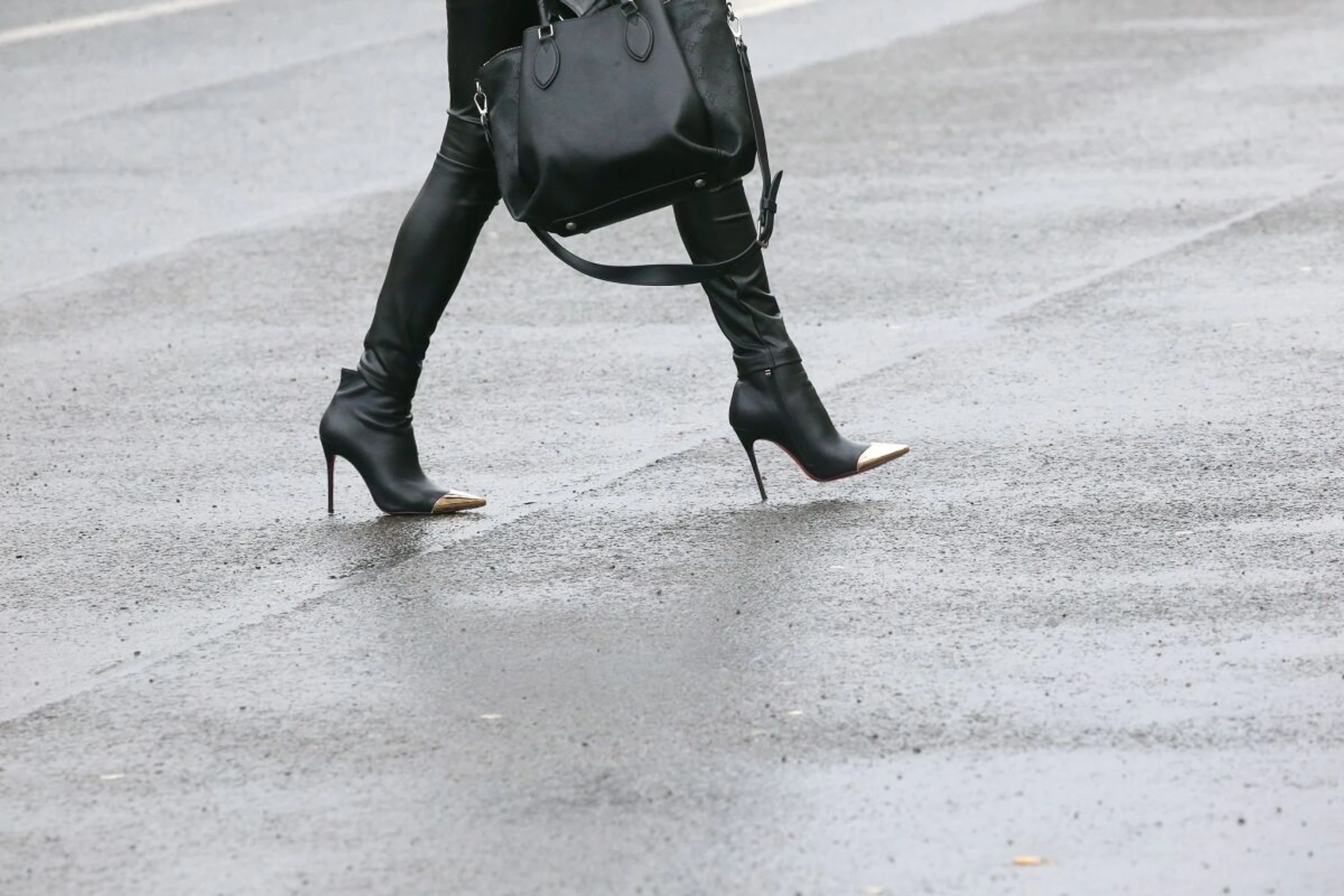 ++ ARCHIVBILD ++ Auf nasser Straße wird der Gang auf High Heels zur Herausforderung