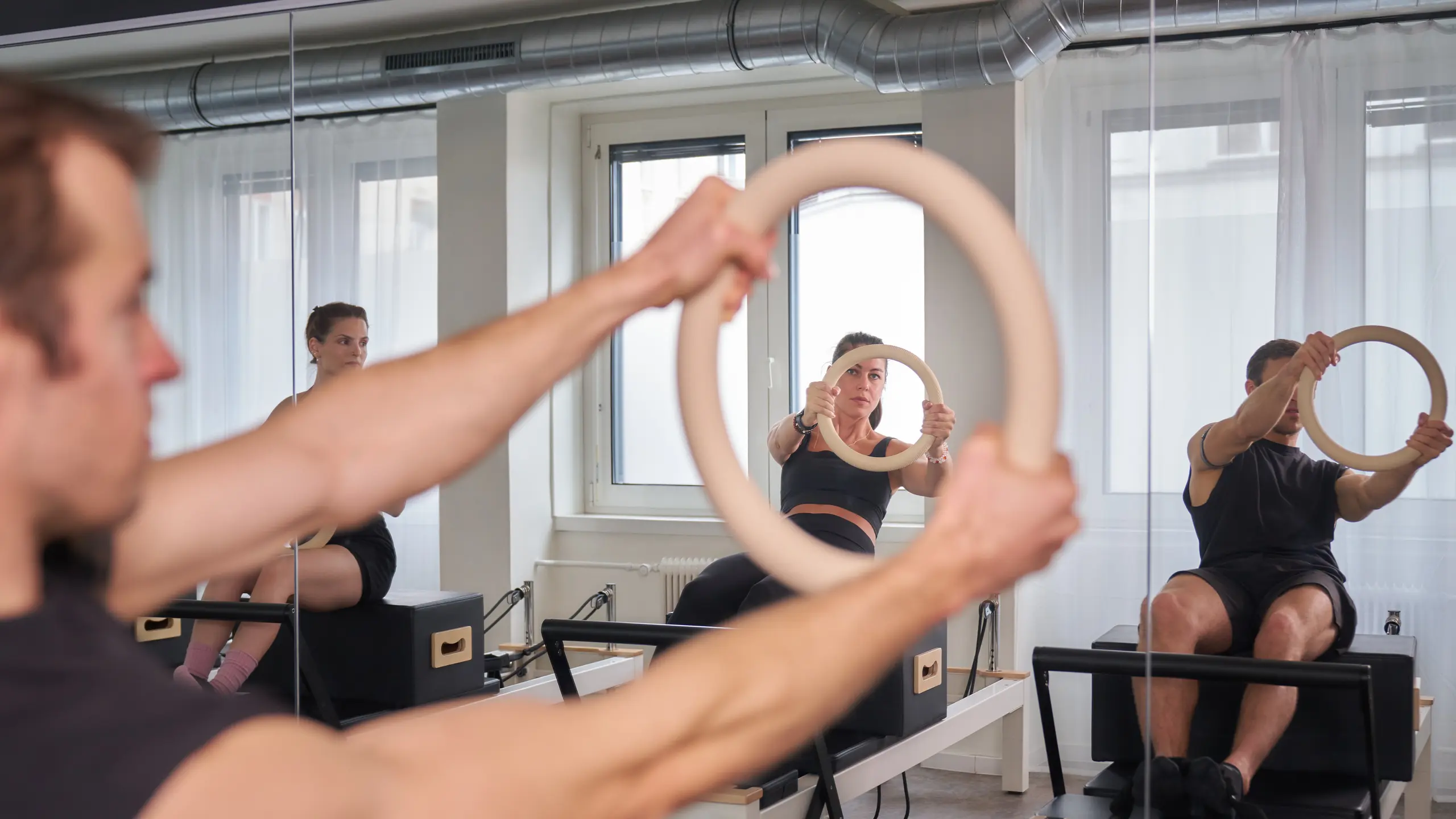 Frauen und ein Mann die Reformer Pilates machen