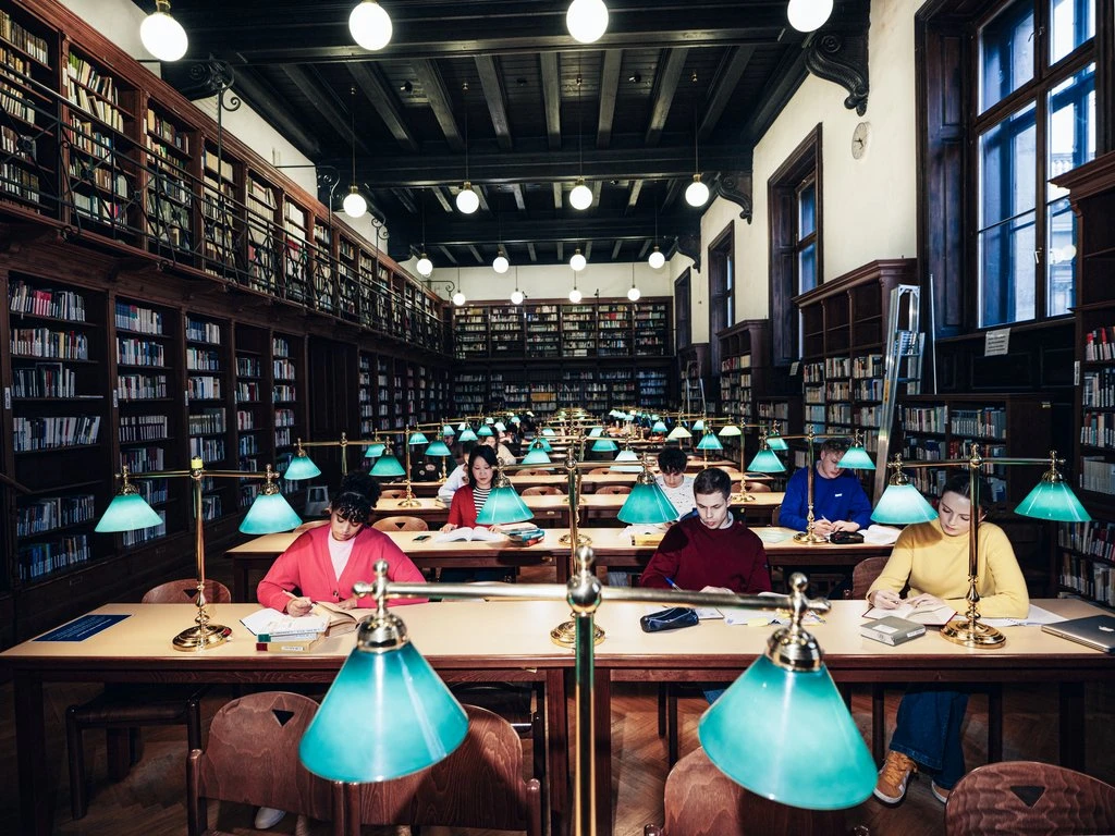 Innenaufnahme einer Bibliothek mit Studierenden an den Tischen