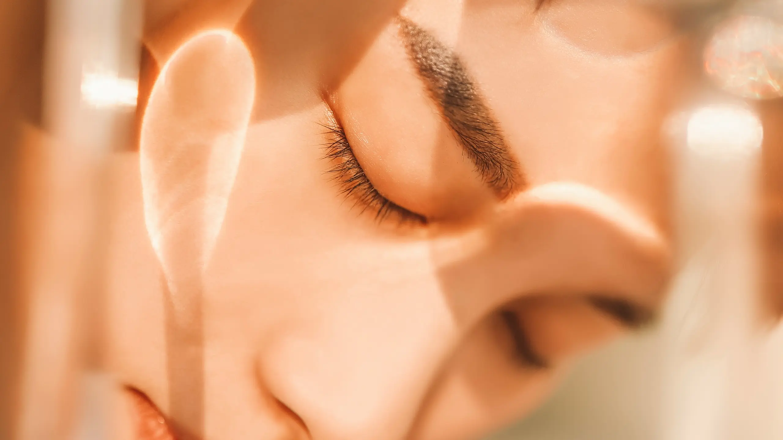 Foto von Gesicht einer Frau mit geschlossenen Augen vor verschwommenem Hintergrund