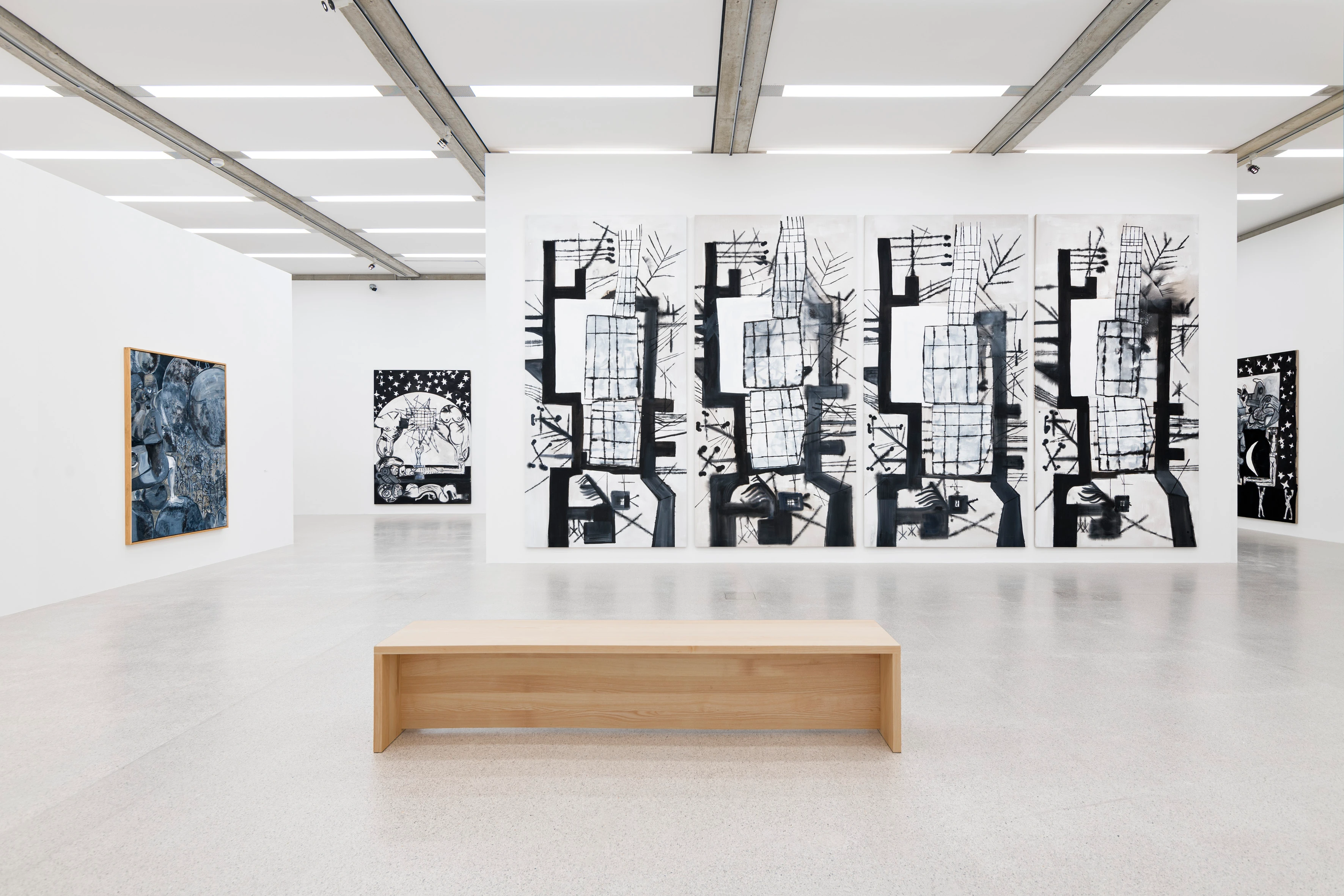 Kunstausstellung mit abstrakten Gemälden und Holzbank in minimalistischer Galerie.