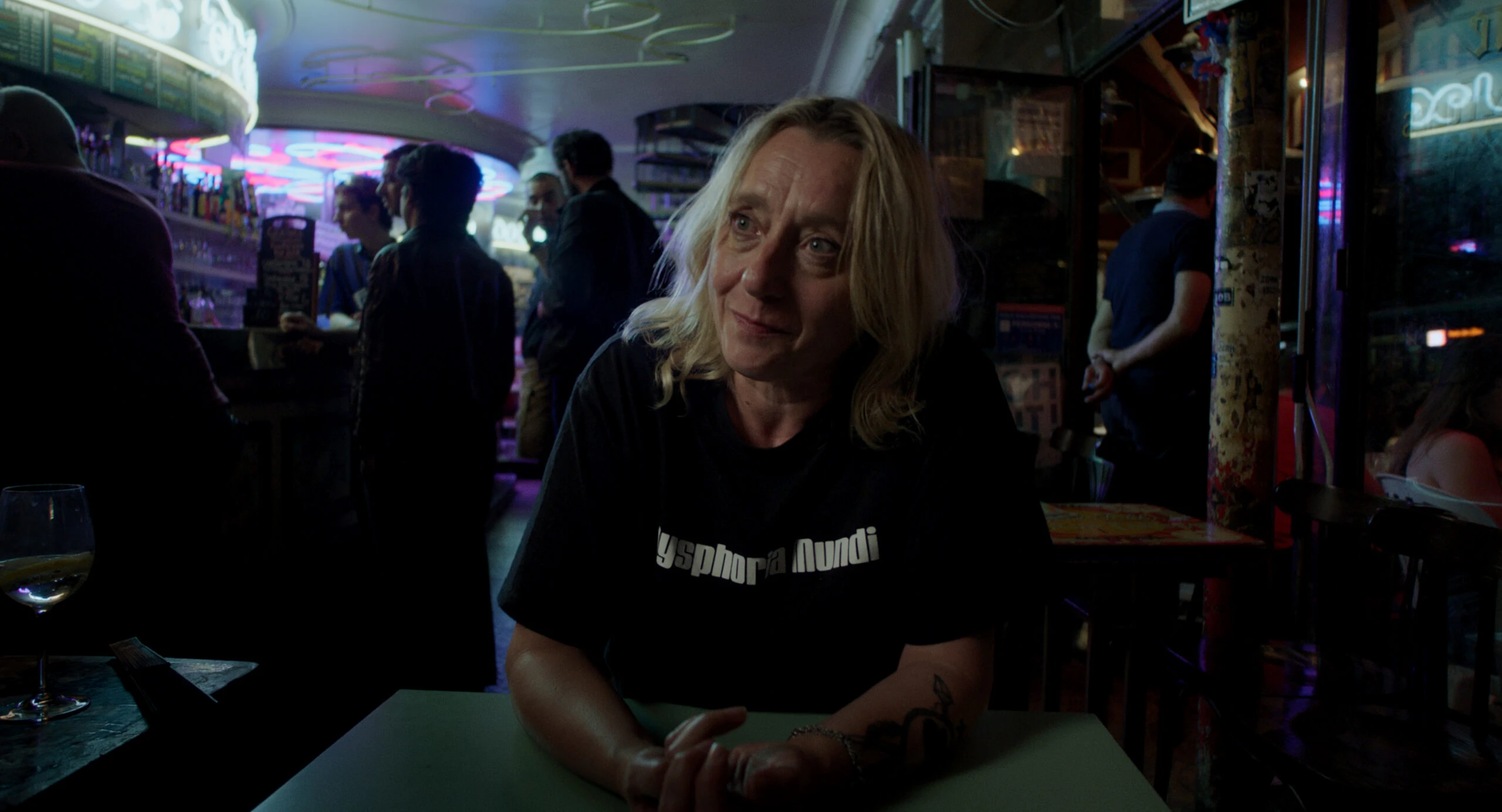 Frau mit blonden Haaren in einer Bar mit der Aufschrift 