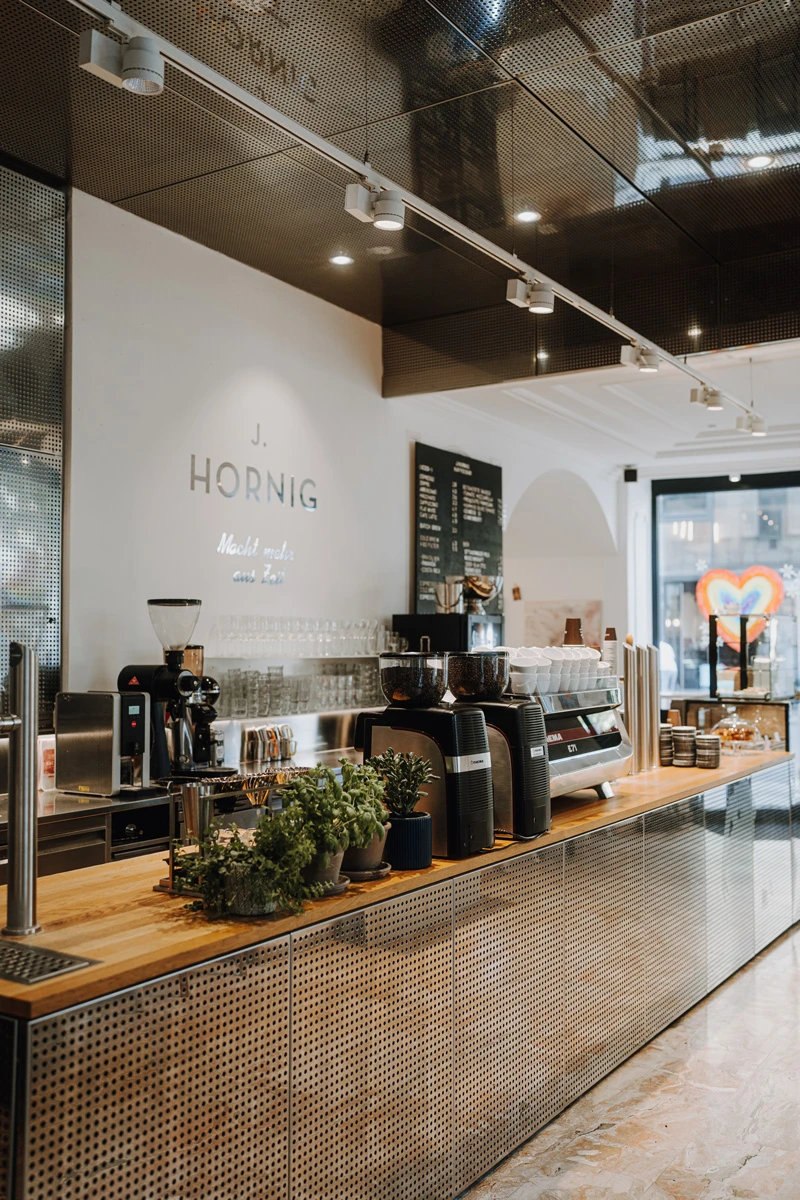 Innenaufnahme einer Bar oder eines Cafés mit Kaffeemaschinen und Pflanzen