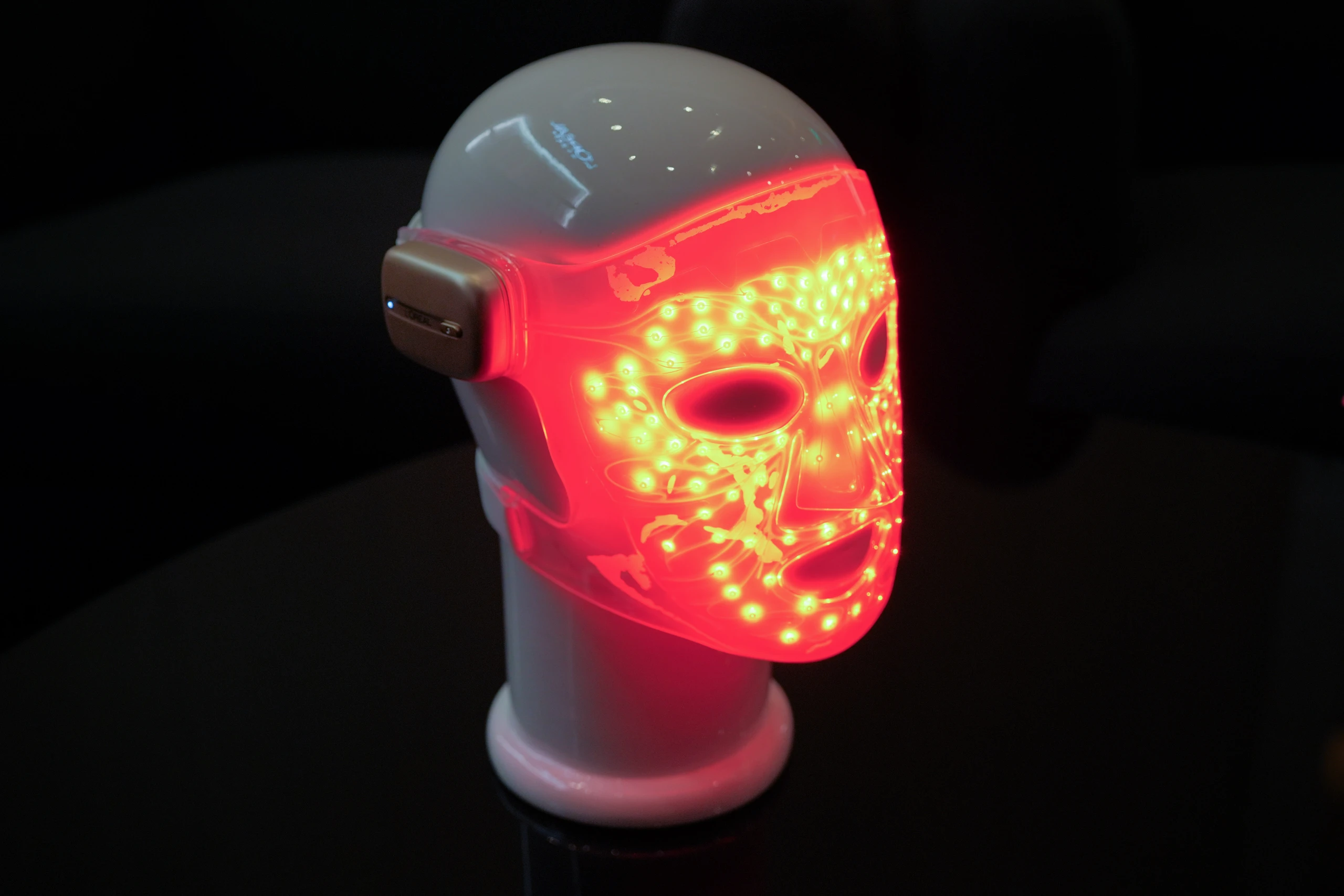 Die LED-Gesichtsmaske auf einem Deko-Kopf