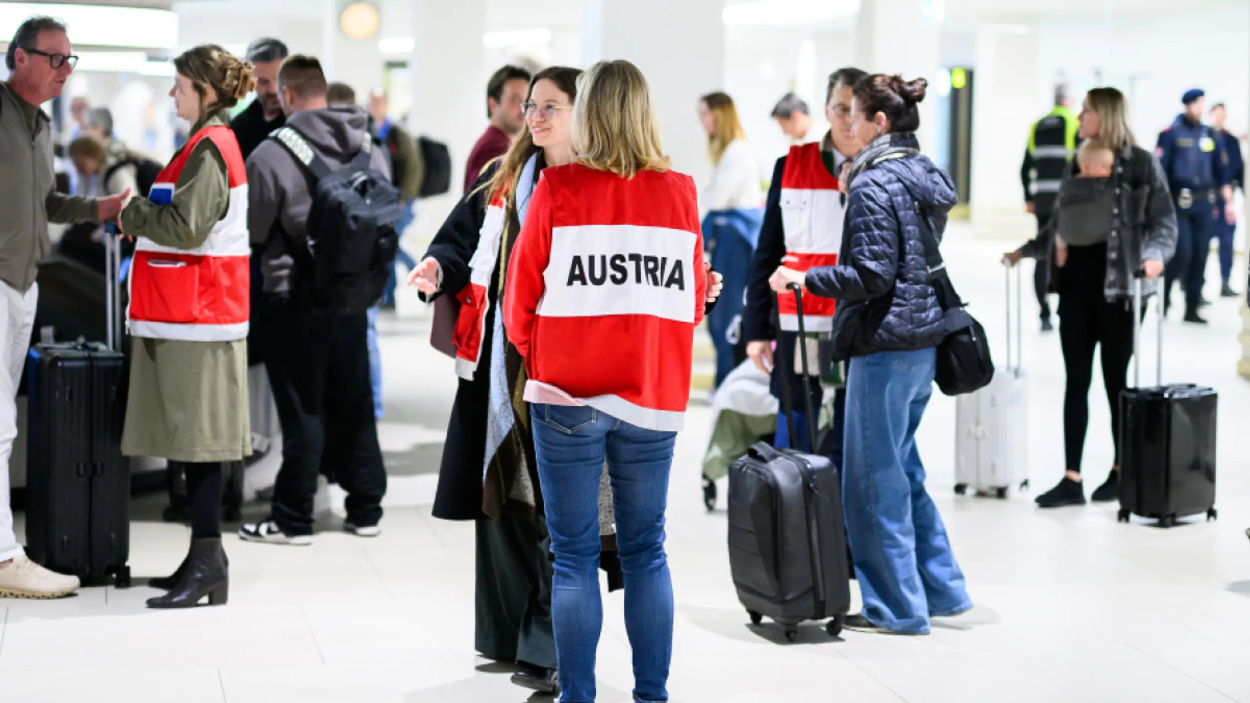 Außenministerin Meinl-Reisinger (M.) mit den angekommenen Fluggästen