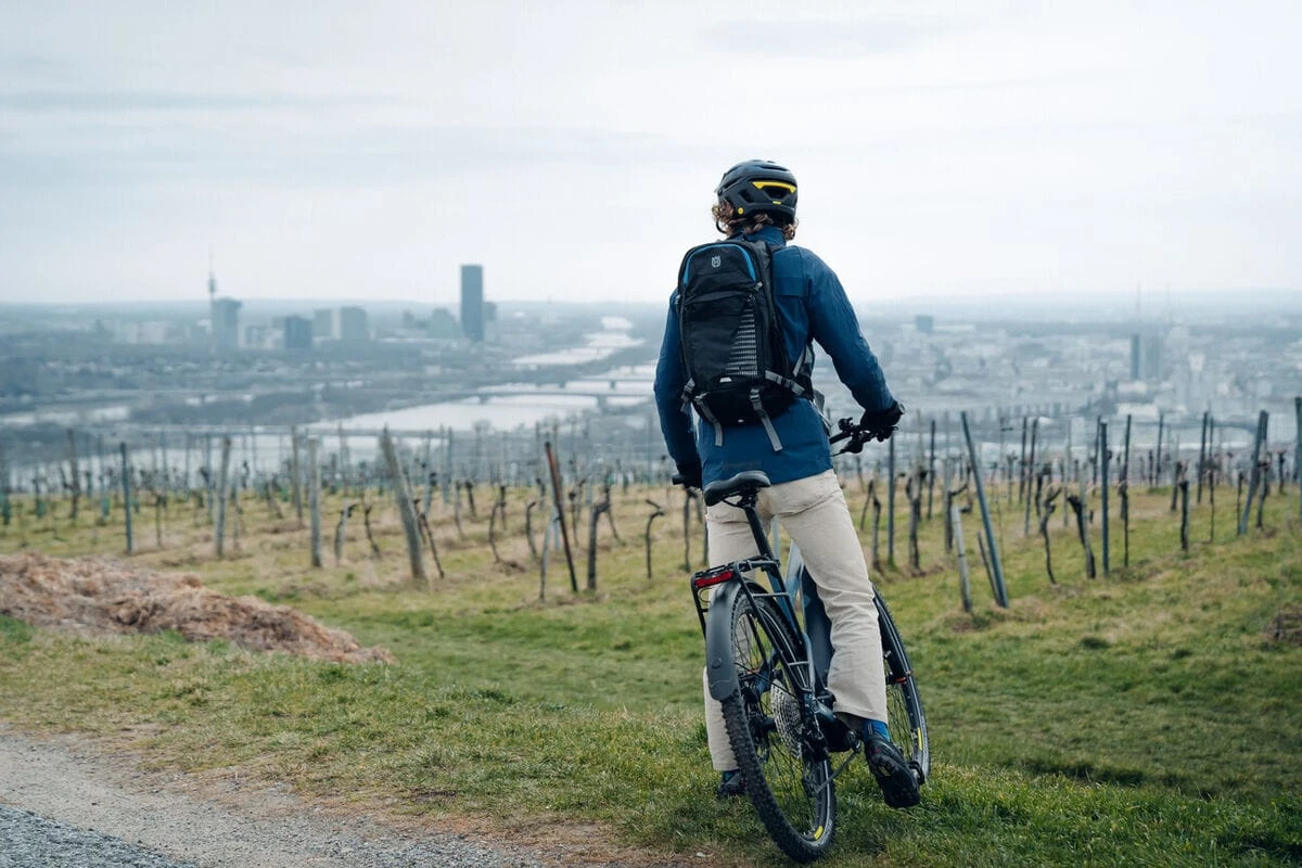 Radfahrer genießt die Aussicht über den Weinbergen auf die Stadt