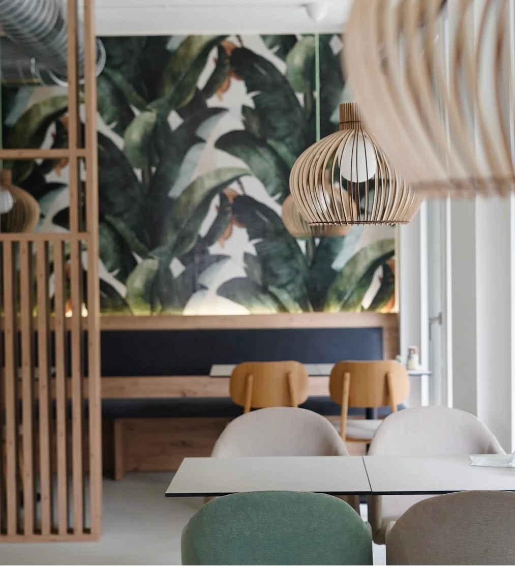 Restaurant Innenraum mit Pflanzenmuster-Tapete und Holzdekoration.