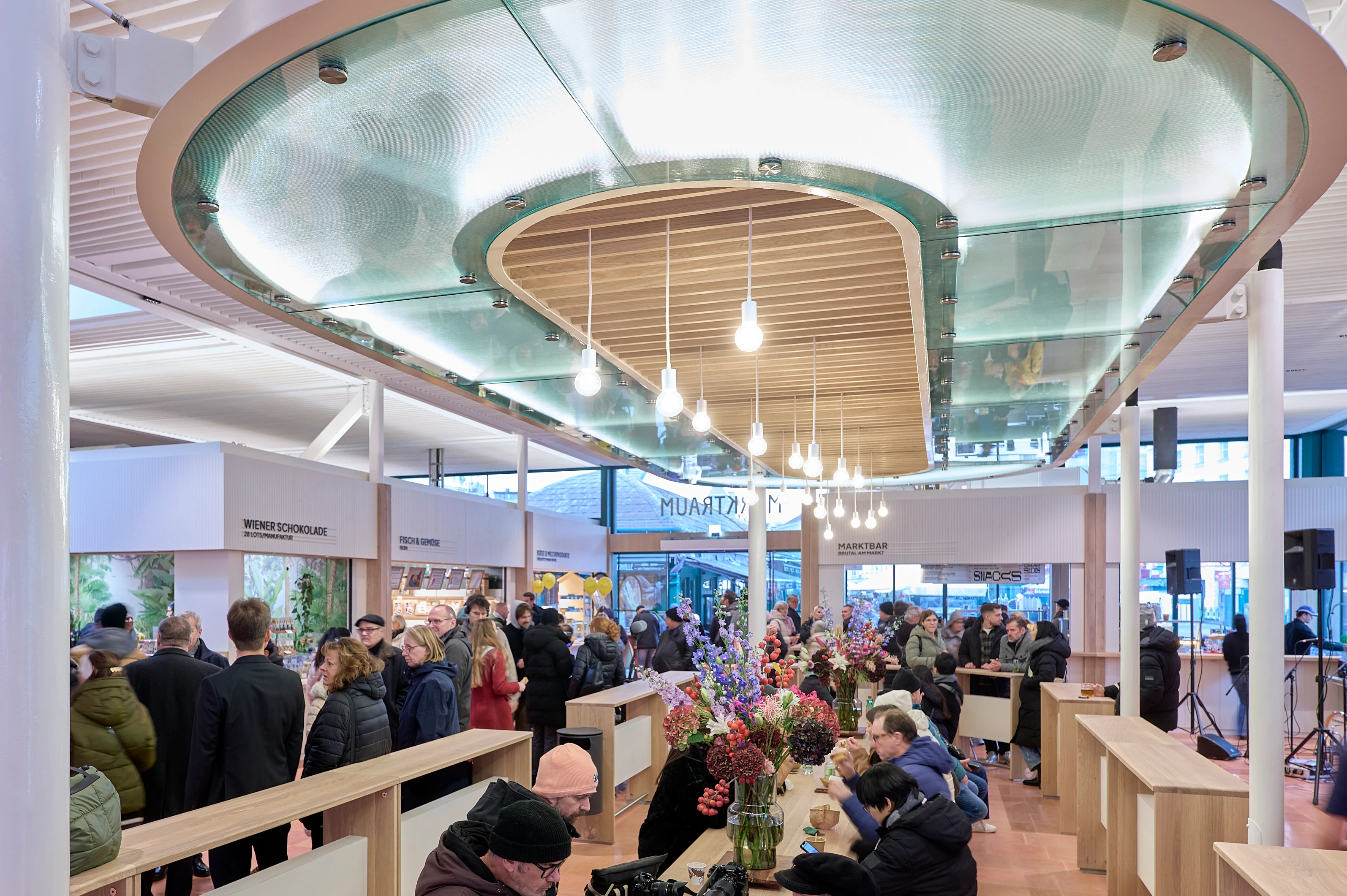 Belebter Marktraum mit Verkaufsständen und Besuchern.