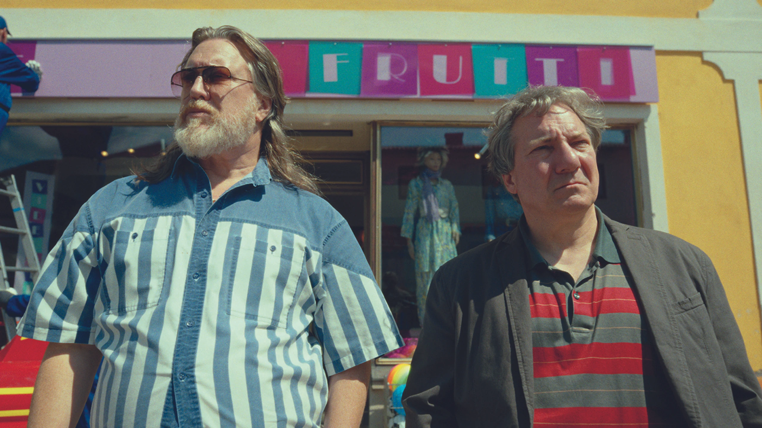 Nicholas Ofczarek und Robert Palfrader stehen vor einem Modegeschäft aus den 80ern