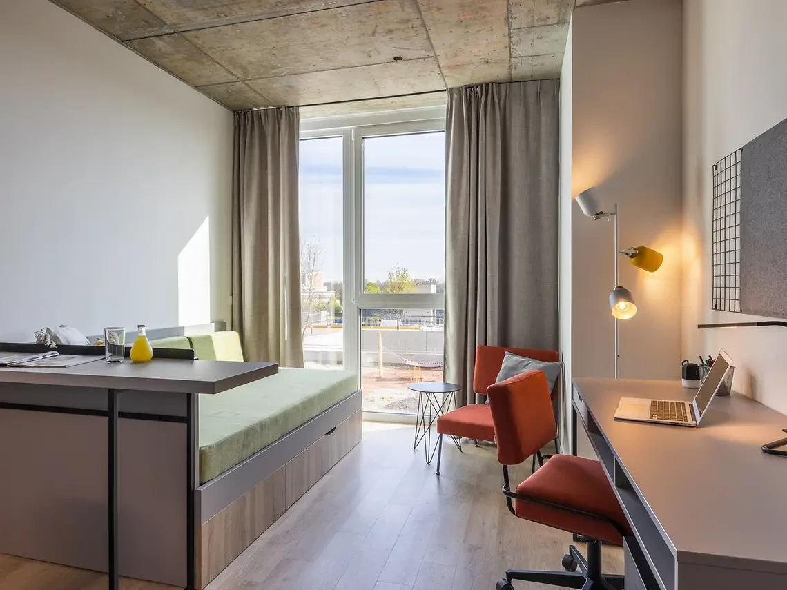Modernes Studentenwohnheim mit Schreibtisch und Bett