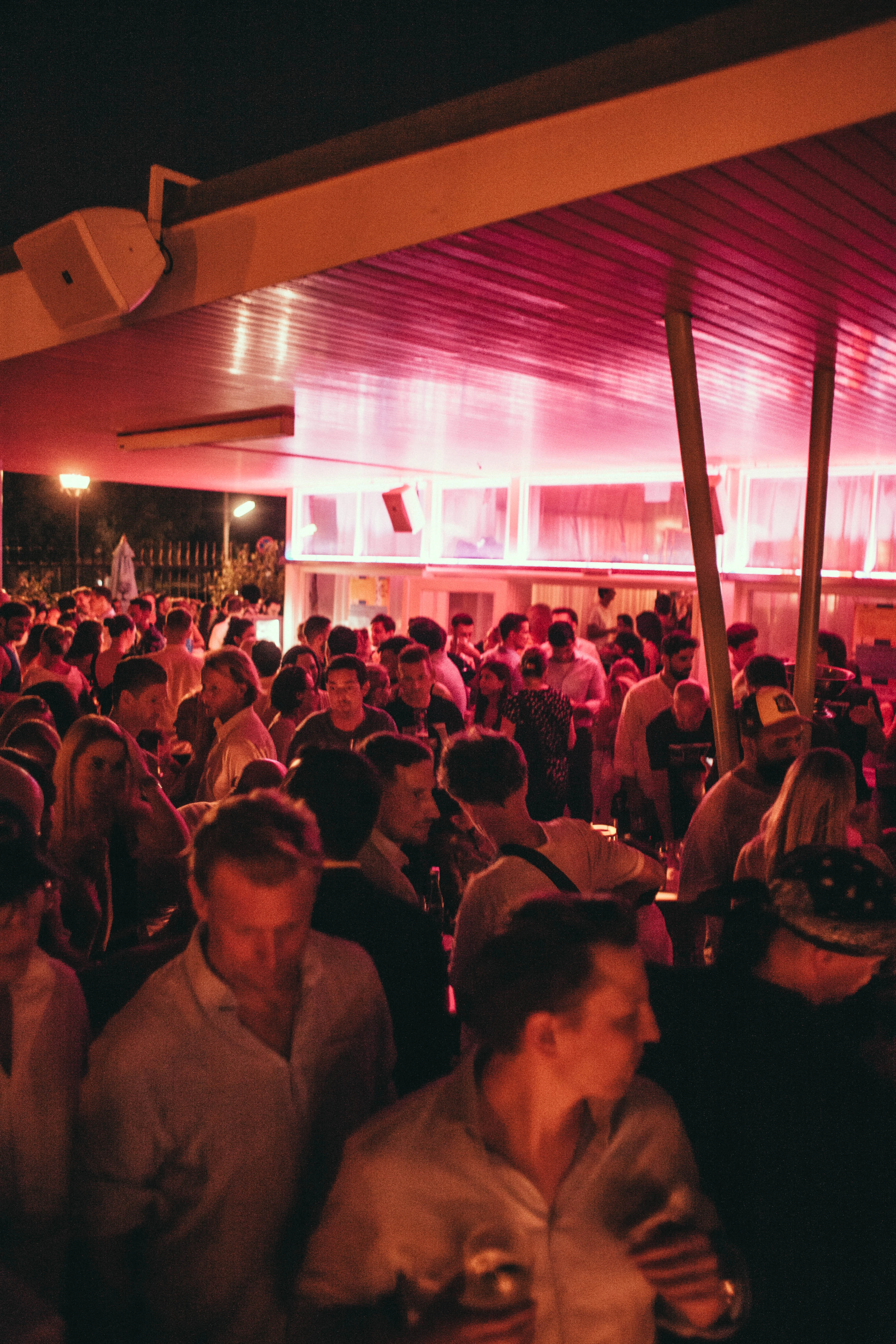 Menschenmenge bei Nachtveranstaltung unter roter Beleuchtung