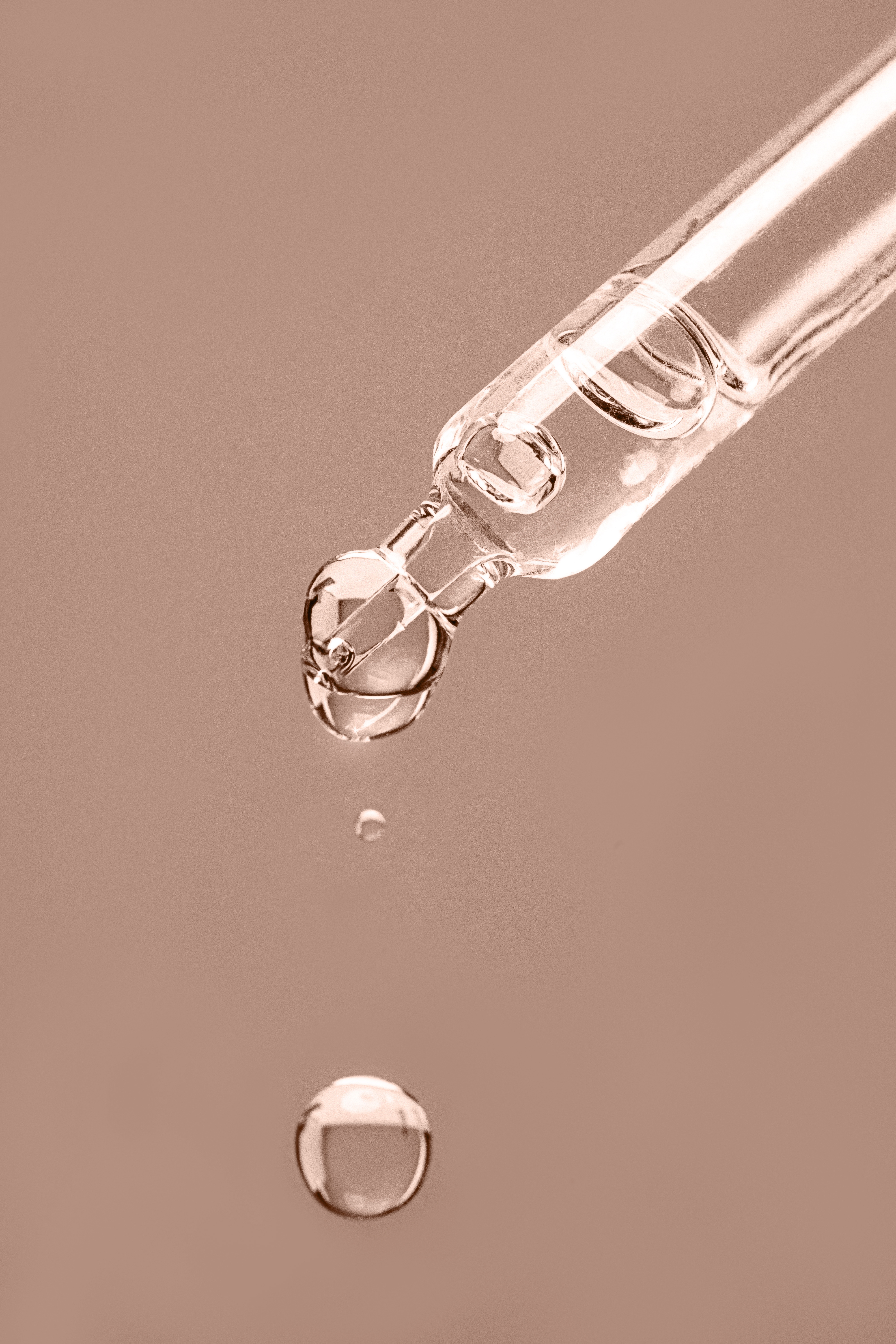 Close-up von Serum-Pipette auf braunem Hintergrund
