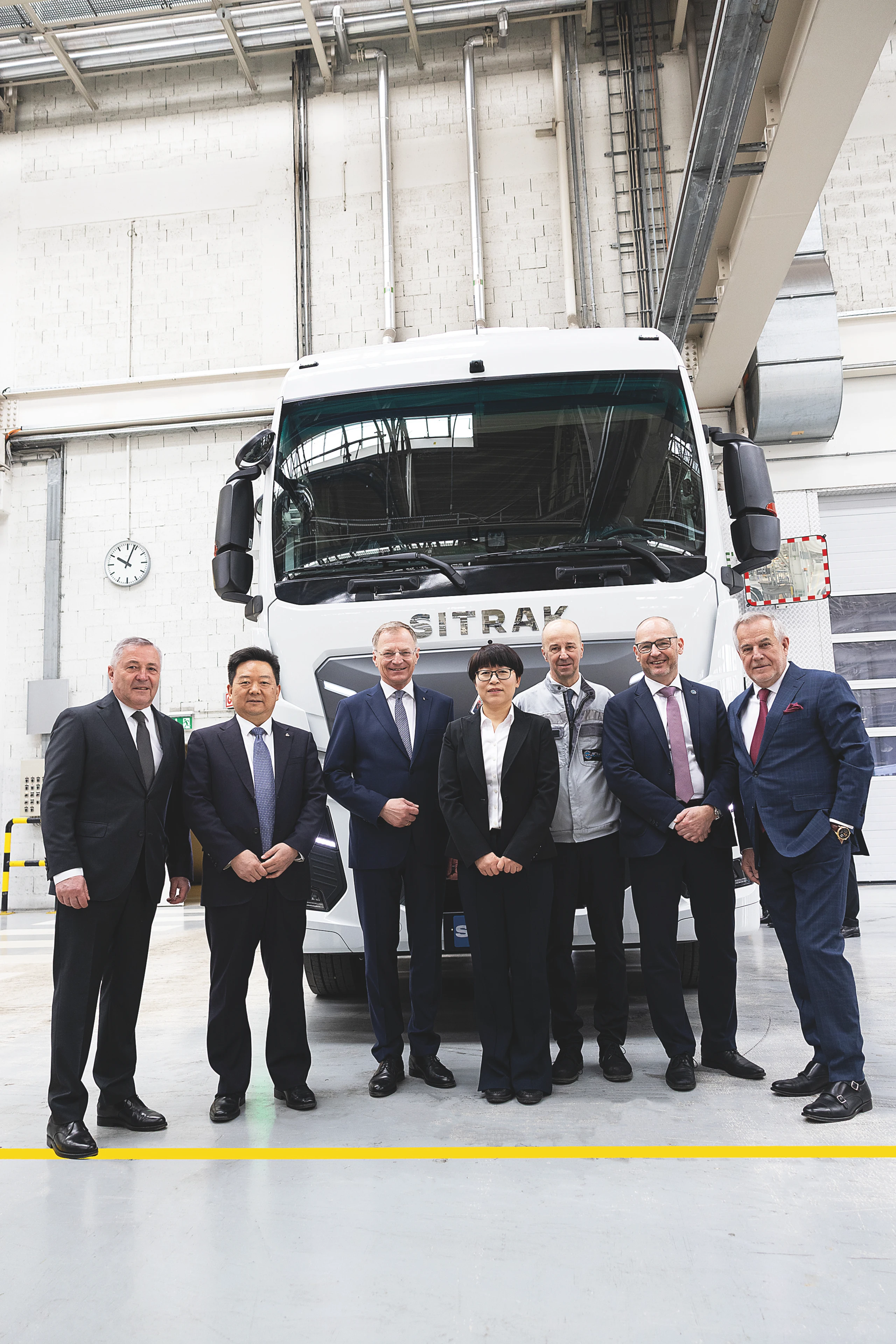 Steyr-Automotive-Eigentümer Siegfried Wolf (rechts) mit Landeshauptmann Thomas Stelzer (3. v. l.), seinem Management und der Delegation aus China den ersten in Steyr montierten Sinotruk-Lkw.