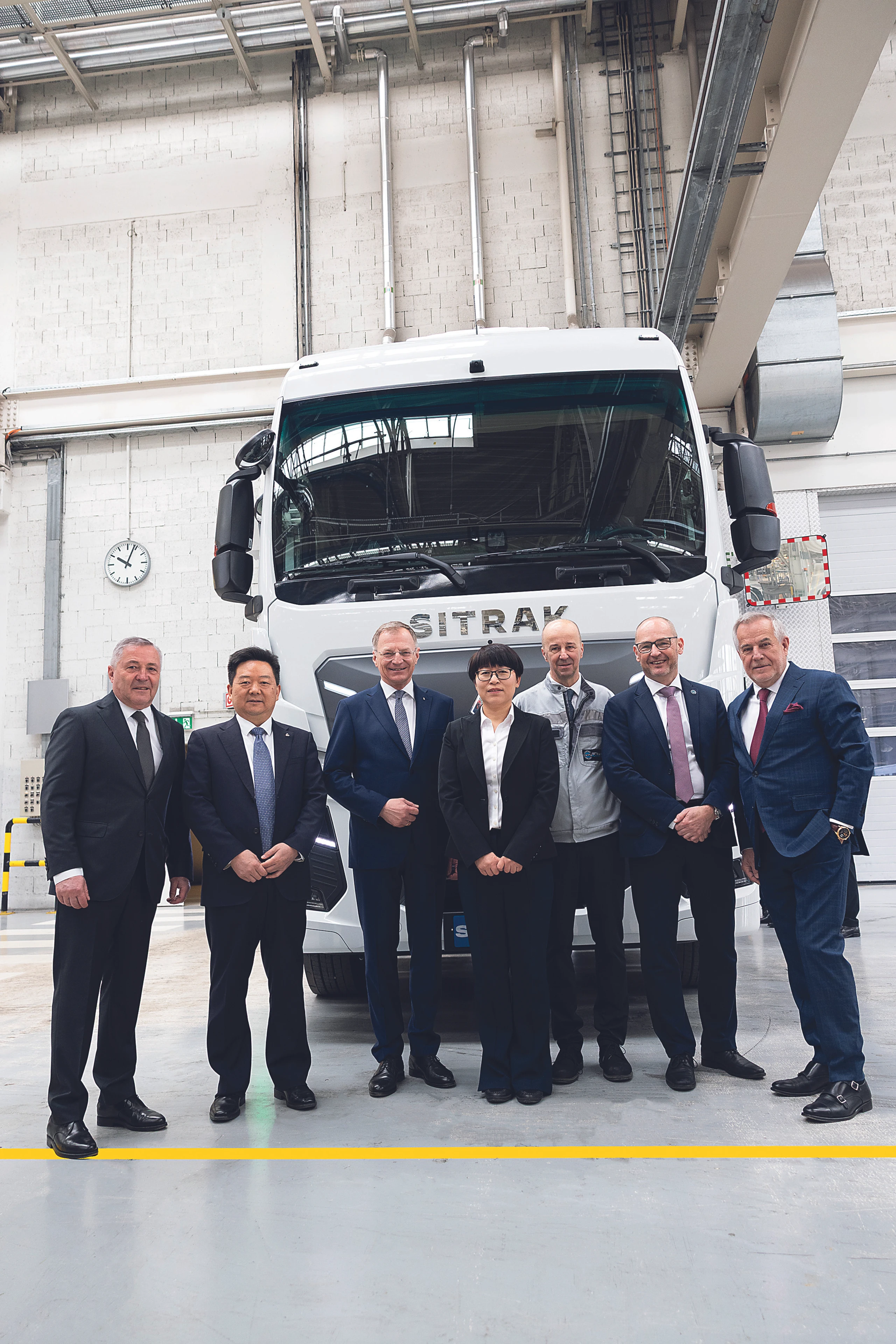 Steyr-Automotive-Eigentümer Siegfried Wolf (rechts) mit Landeshauptmann Thomas Stelzer (3. v. l.), seinem Management und der Delegation aus China den ersten in Steyr montierten Sinotruk-Lkw.