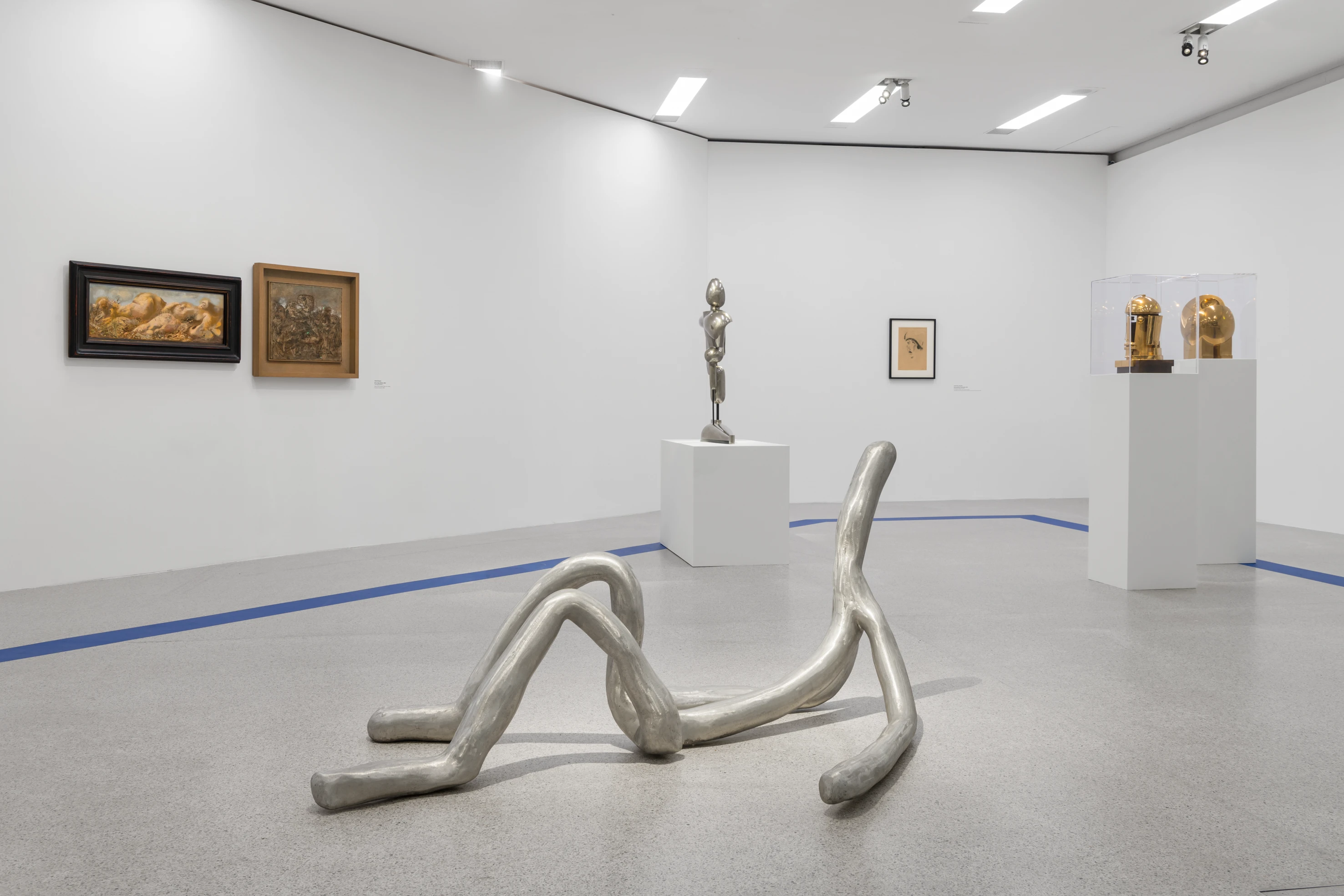 Ausstellung mit Skulpturen und Gemälden in einem Museum.