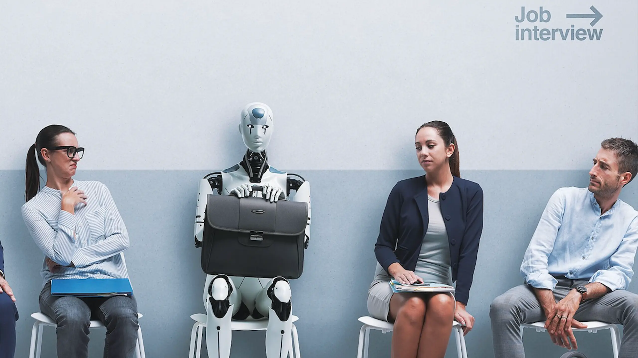© istockphoto Personen warten in einem Zimmer auf ihr Bewerbungsgespräch. Auf einem Suhl sitzt ein Roboter als Sinnbild für KI.