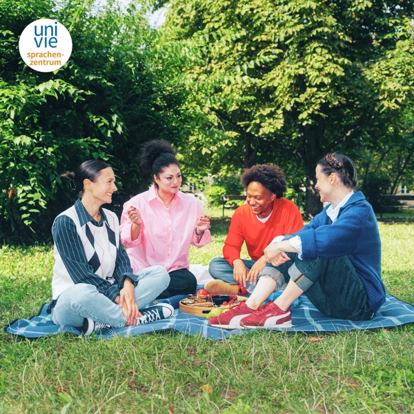 Freundesgruppe beim Picknick im Park des Uni Vie Sprachenzentrums