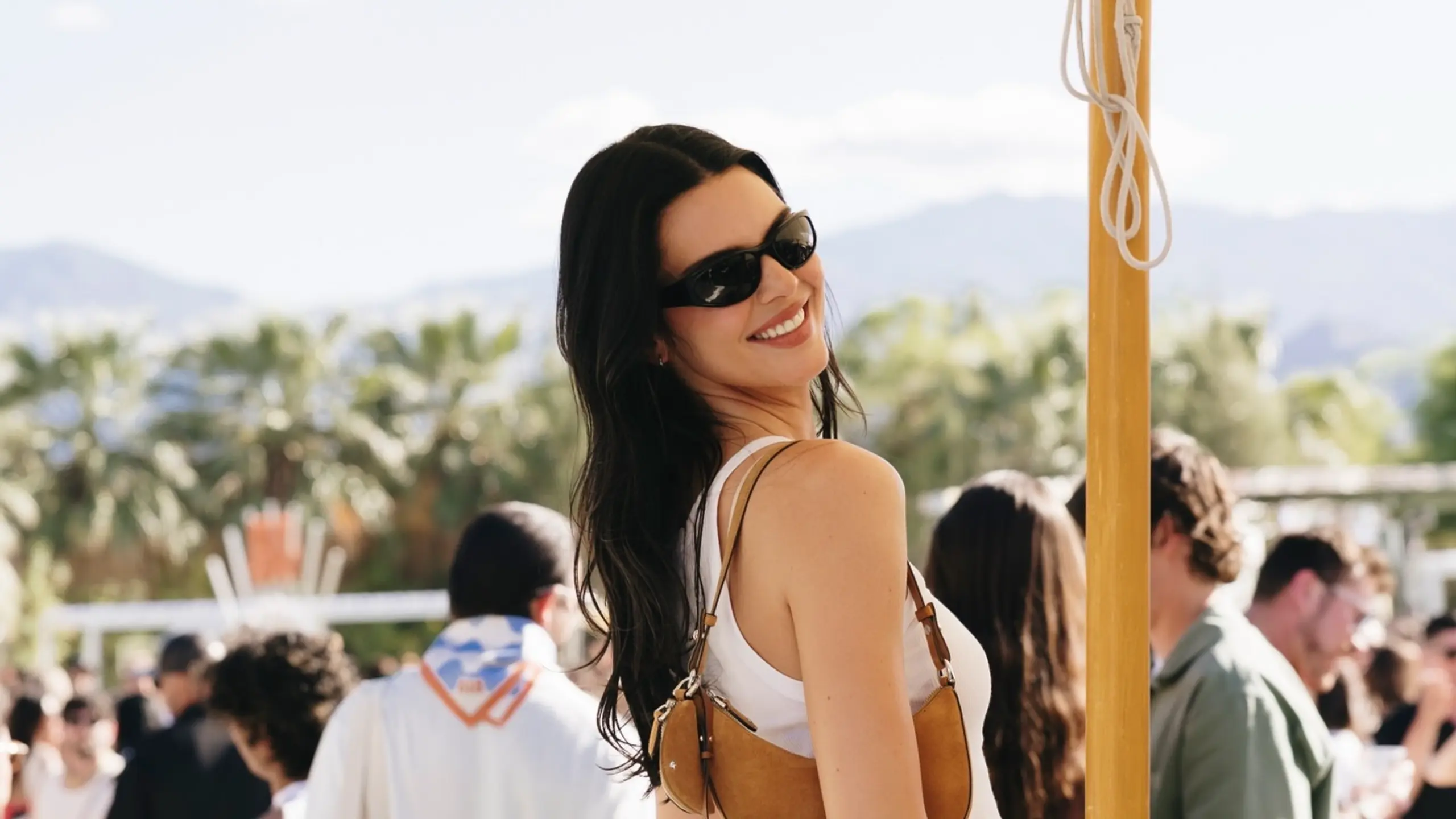 Kendall Jenner auf Festival mit weißen Shorts, weißem Tanktop und brauner Half-Moon-Bag