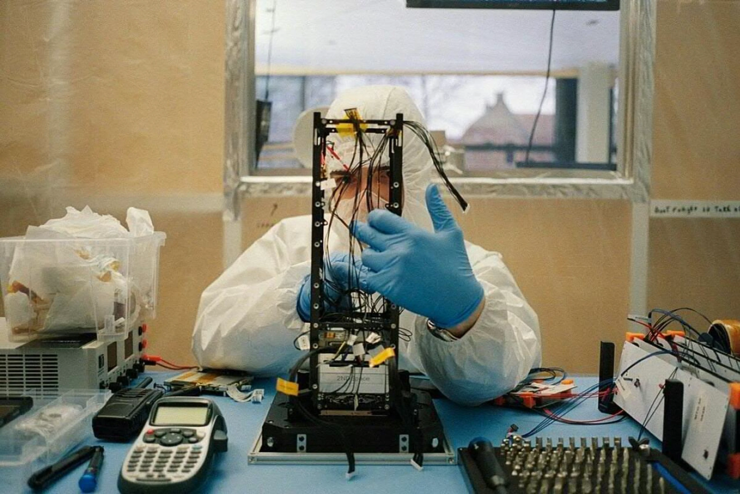 Ein Ingenieur von Tumbleweed arbeitet am Satelliten "Oasis Alpha"