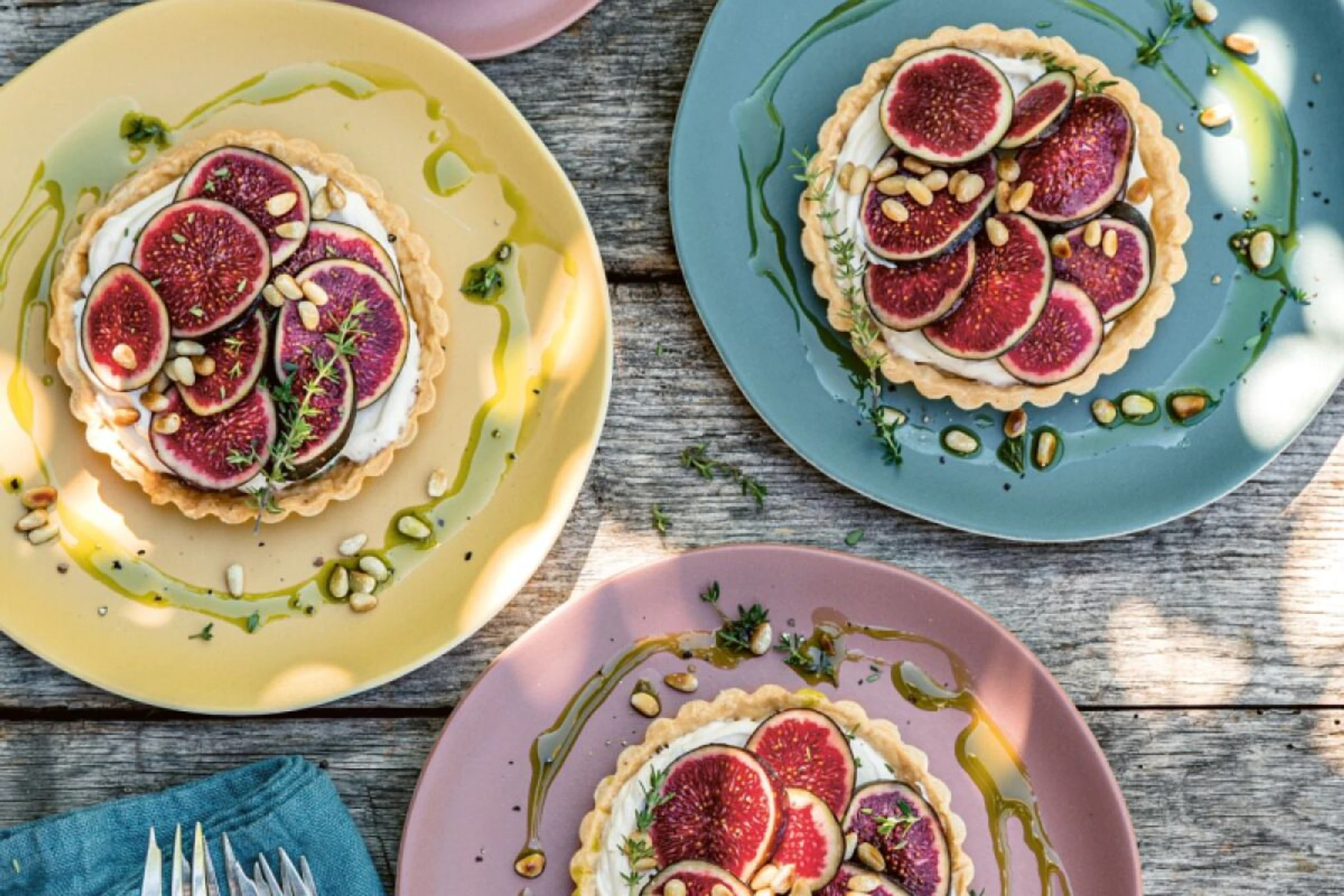 Die Tartelettes mit Pinienkernen bestreuen und mit Thymian dekorieren