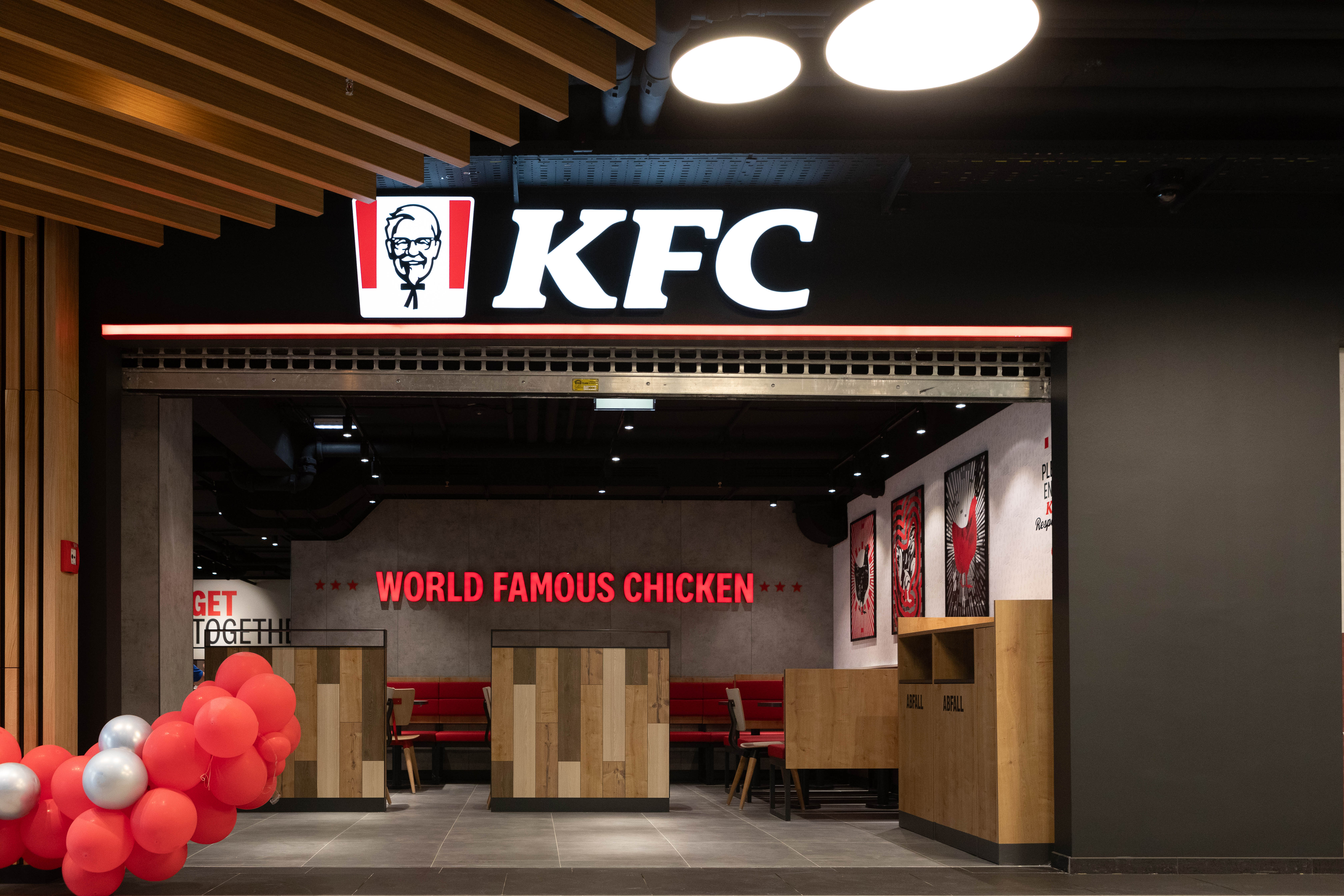 Eingangsbereich der KFC-Filiale Amstetten mit Logo, Sitznischen und Ballondekoration