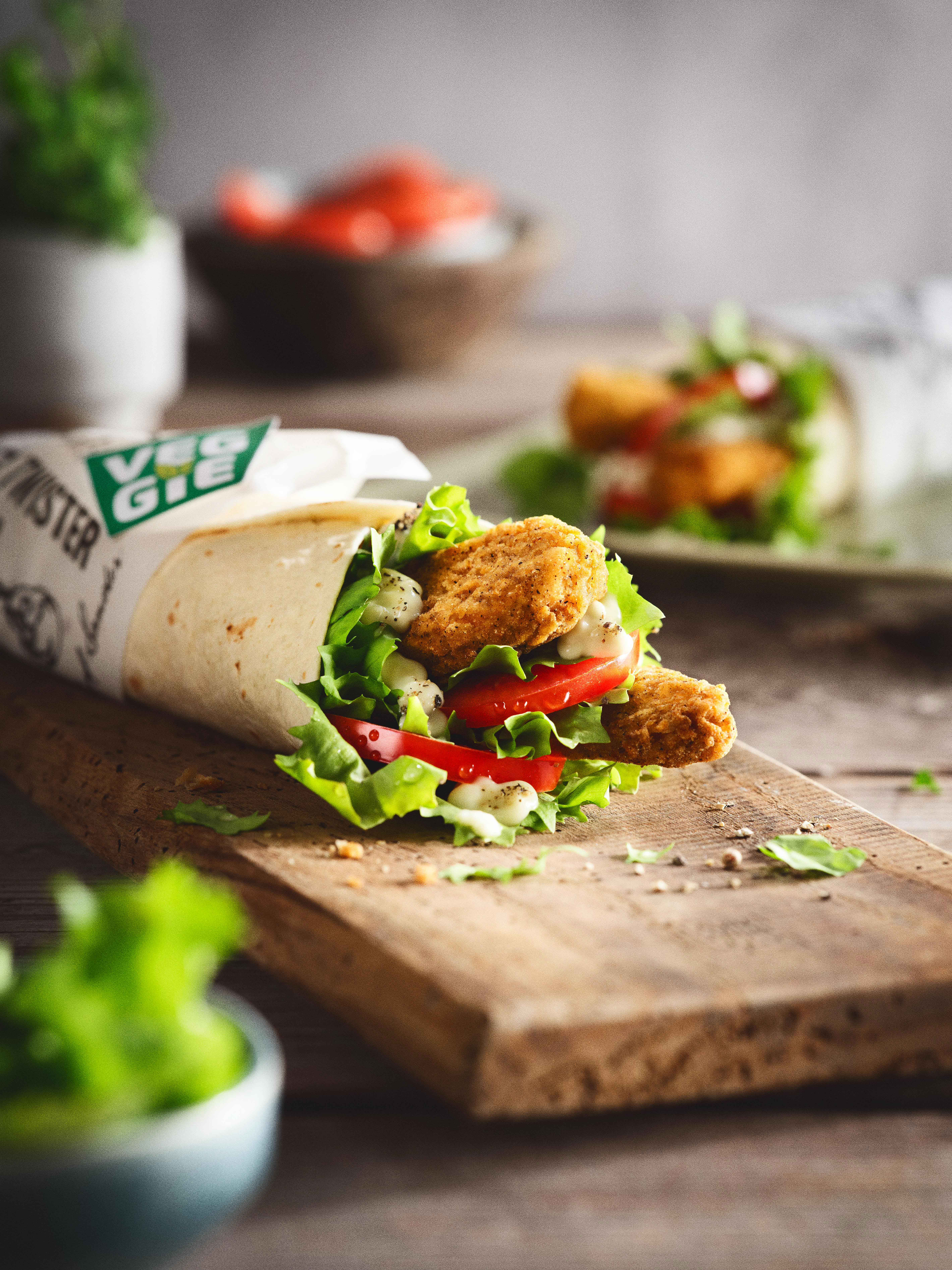 KFC Veggie Twister Wrap mit Salat und Tomaten auf Holzbrett