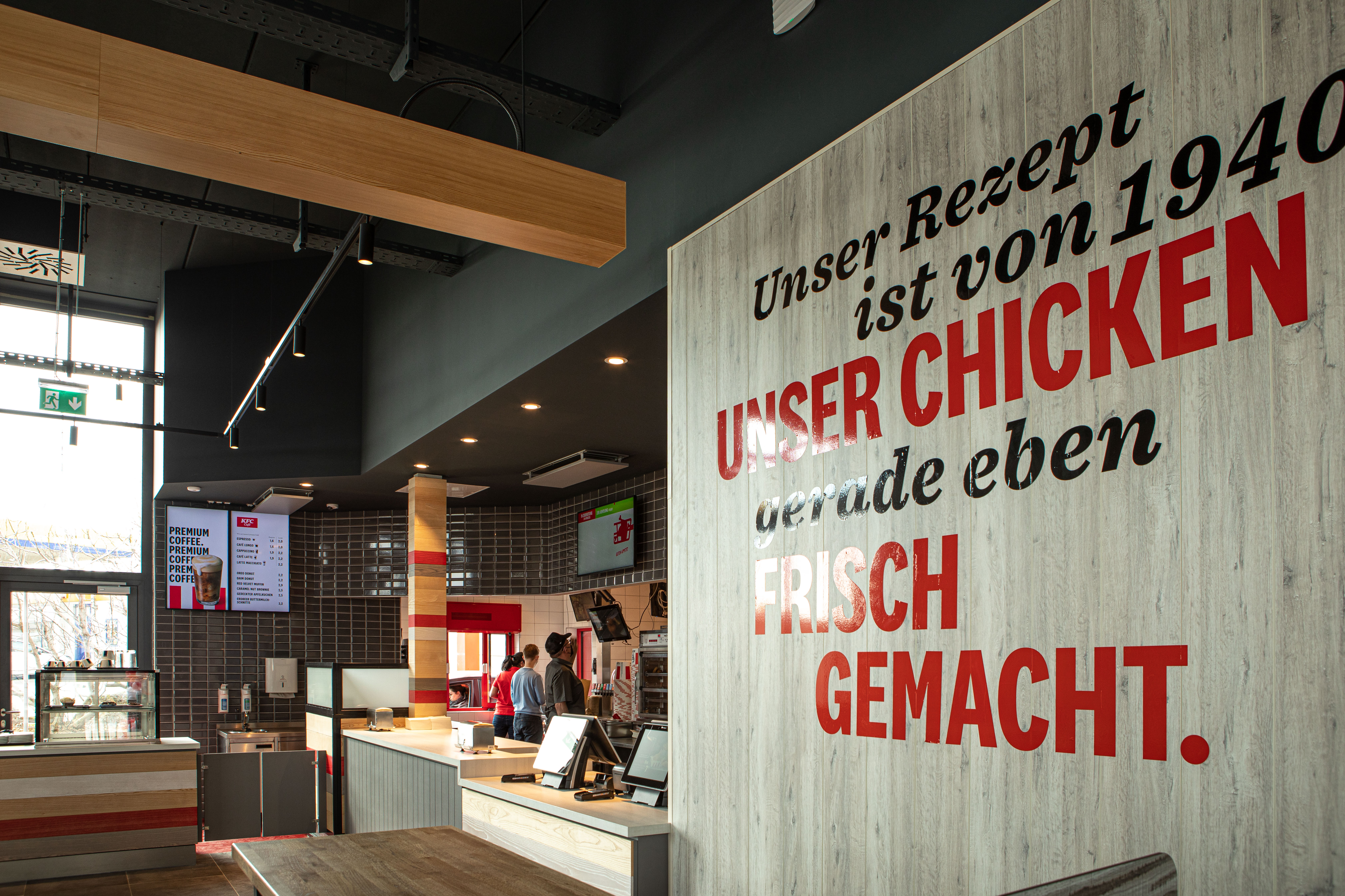 Wandtext 'Unser Chicken gerade eben frisch gemacht' im Eingangsbereich der KFC-Filiale Parndorf